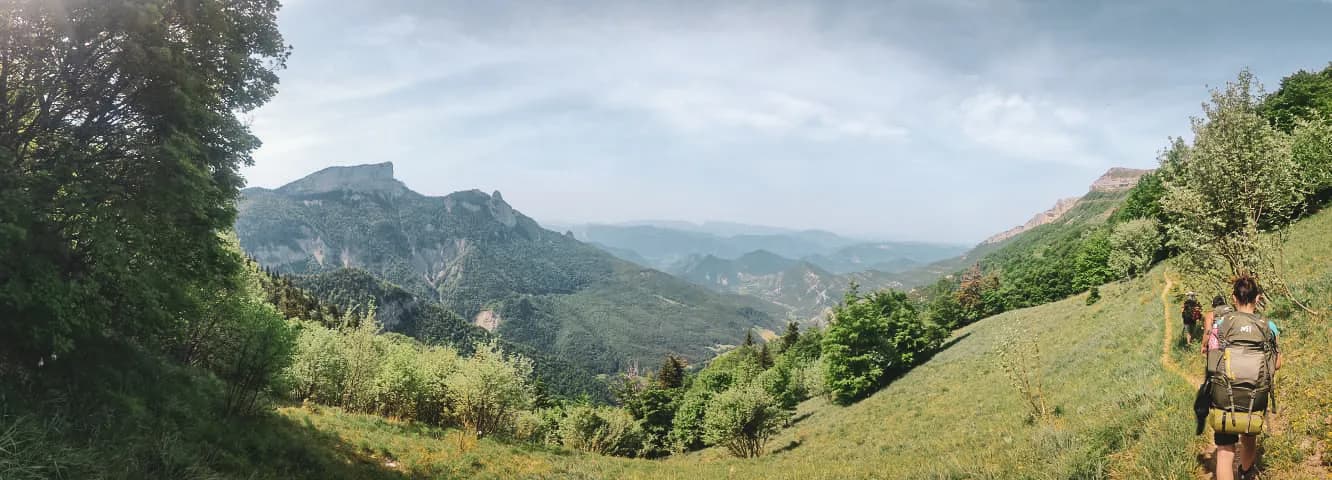 Een groen panorama van de Vercors met wandelaars, een uitnodiging voor avontuur in het hart van de natuur.