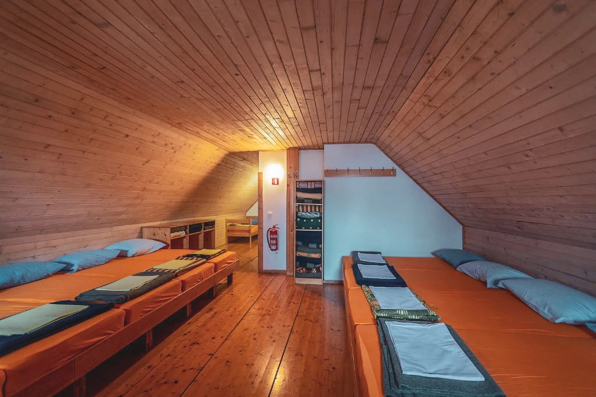 Chambre chaleureuse en bois, lits confortables, ambiance conviviale pour une aventure alpine.