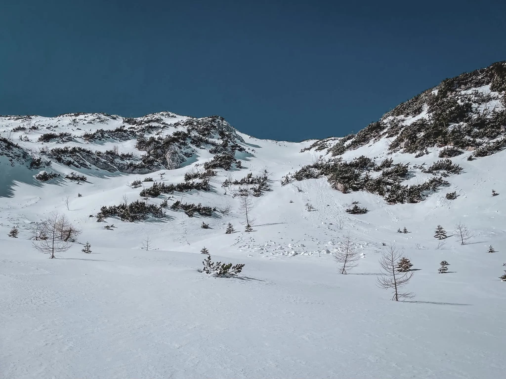 Paysage enneigé des Alpes juliennes, vallées glaciaires et ciel bleu éclatant invitant à l'aventure.