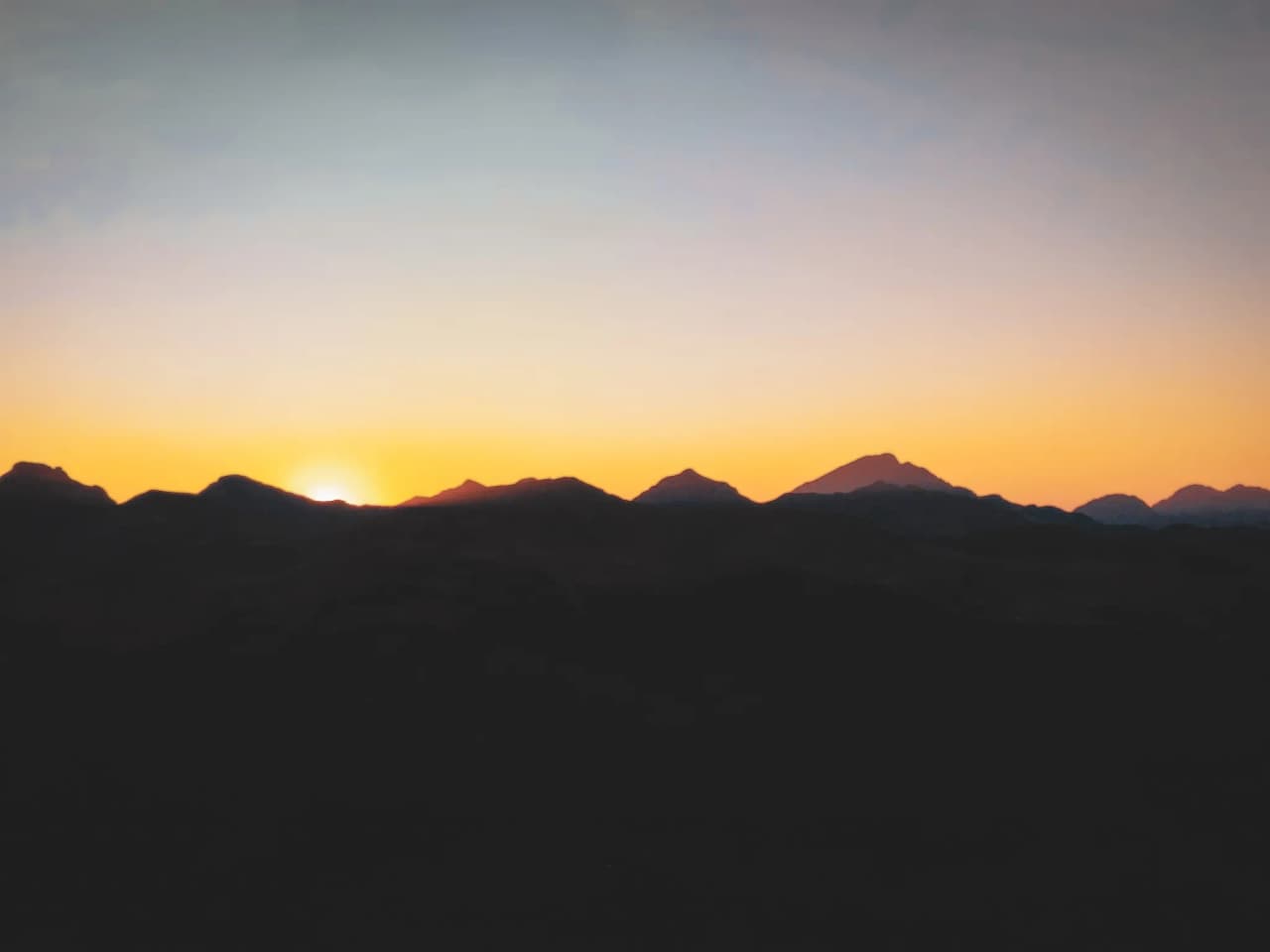Sunrise over the mountains, illuminating an idyllic and soothing Alpine landscape.