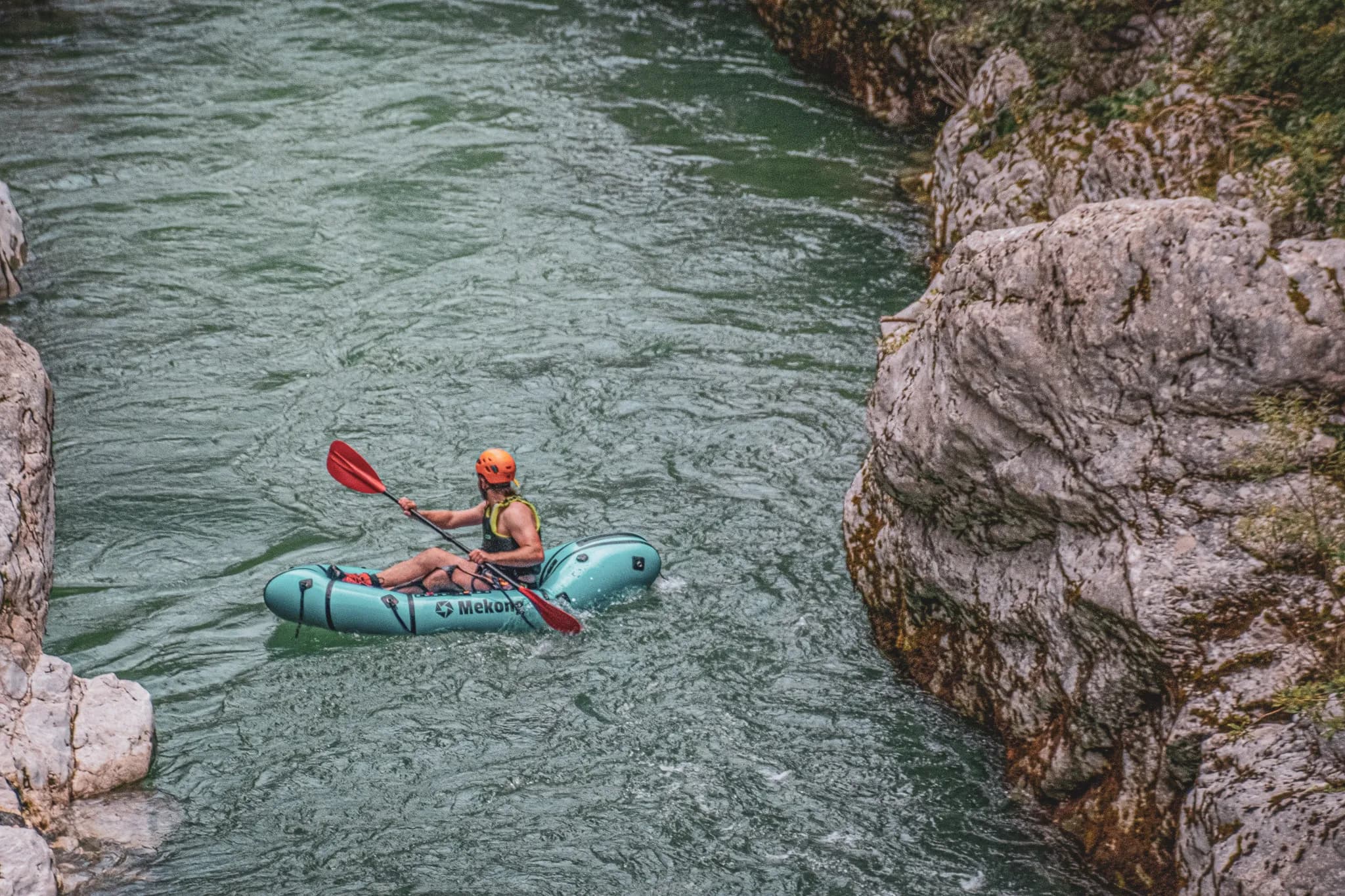 Un aventurier pagaye dans des eaux cristallines entourées de falaises escarpées en Slovénie.