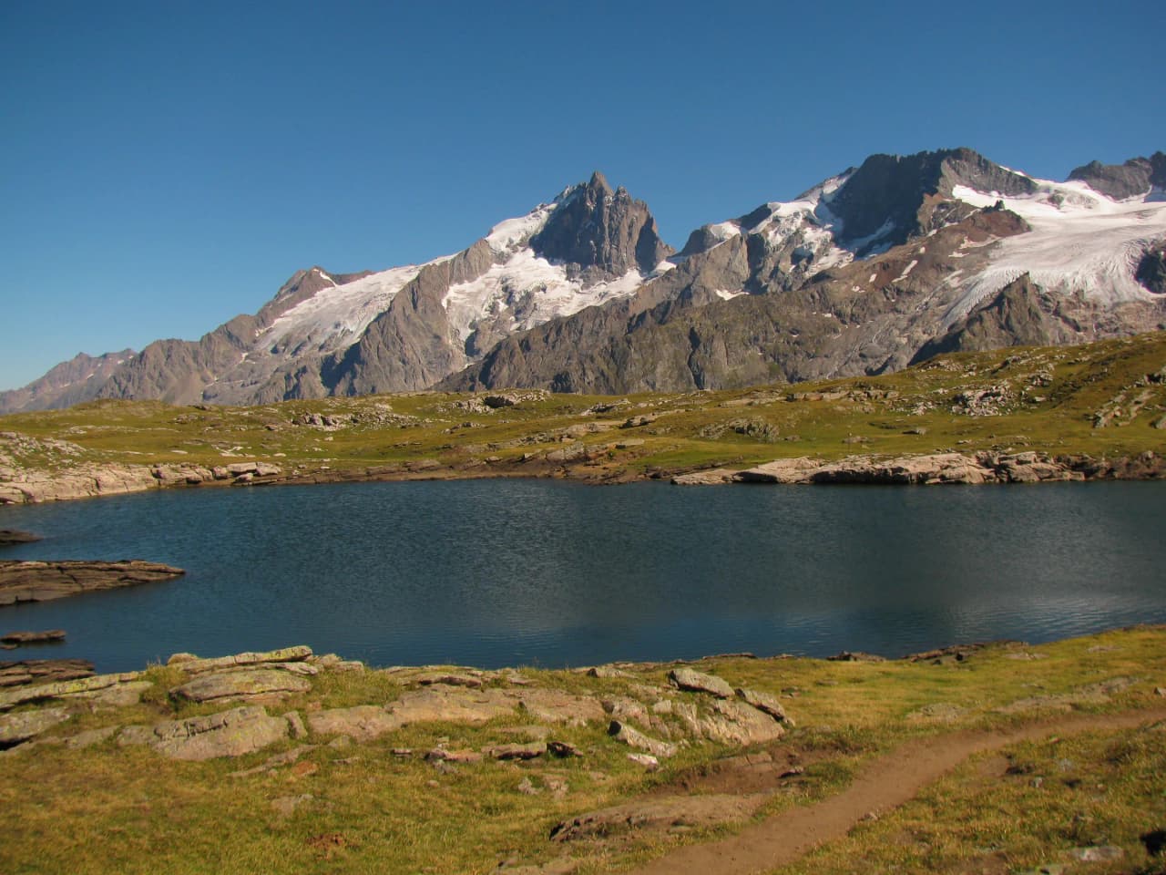 Lacs turquoise entourés de montagnes majestueuses sous un ciel bleu éclatant. Évasion garantie !