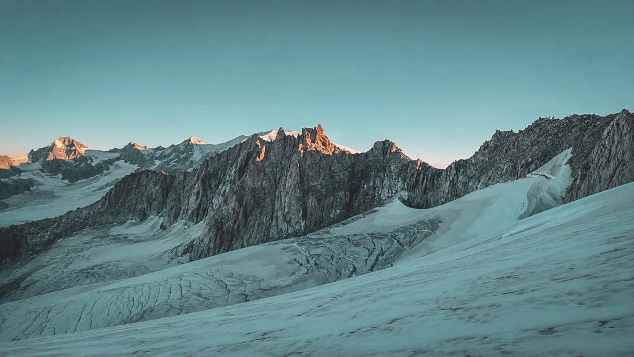 Vue panoramique des montagnes majestueuses des Alpes, illuminées par le soleil.