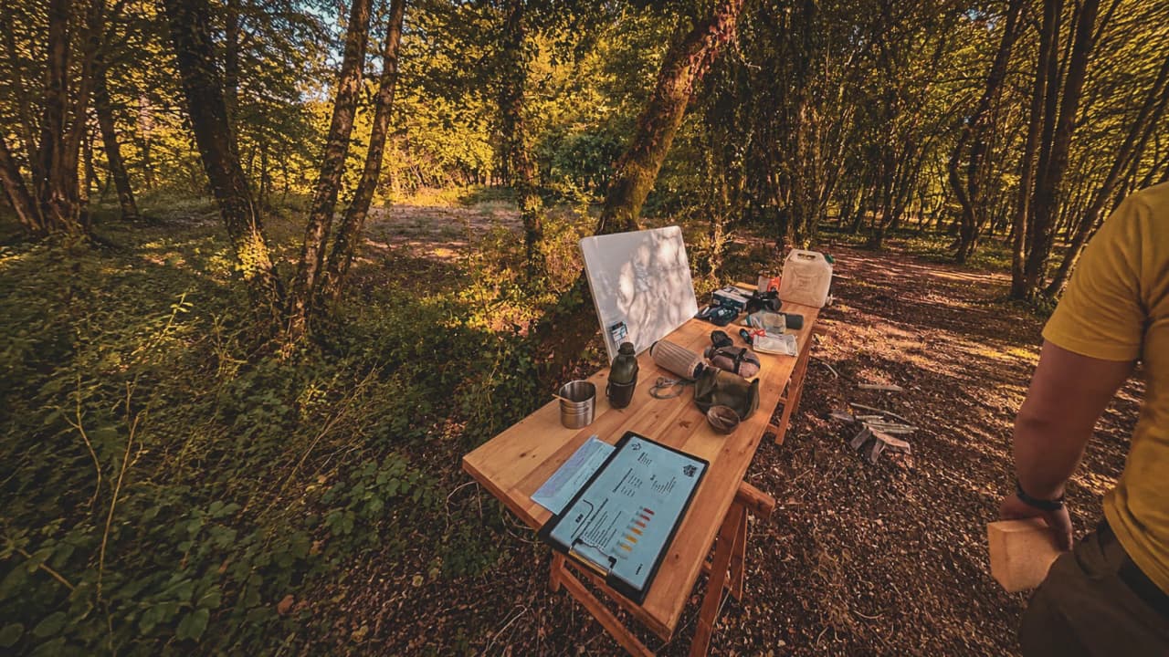 Table en bois dans une forêt ensoleillée, préparée pour un stage de survie en pleine nature.
