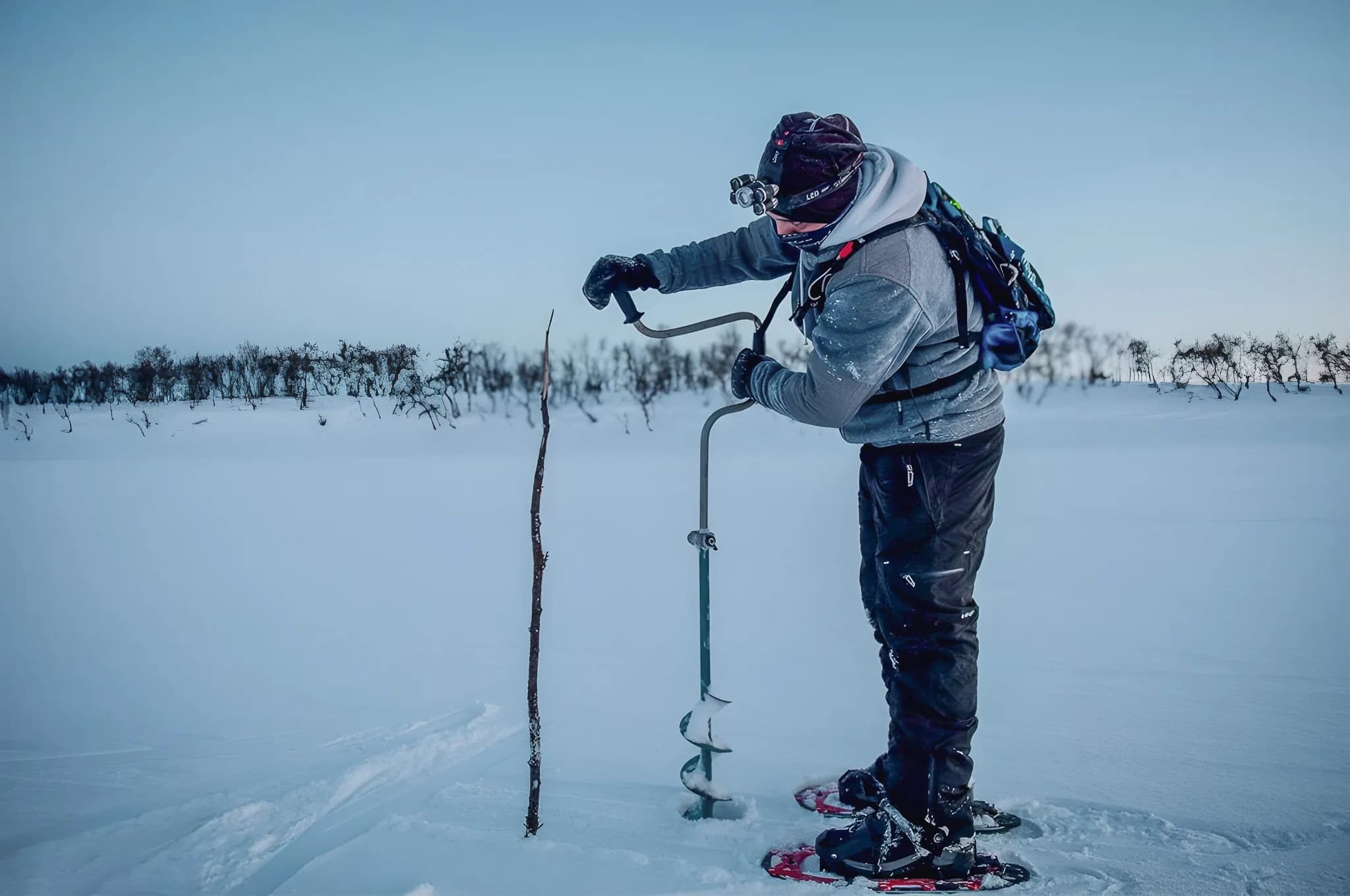 An adventurer on snowshoes cuts through the snow, exploring snowy Lapland.