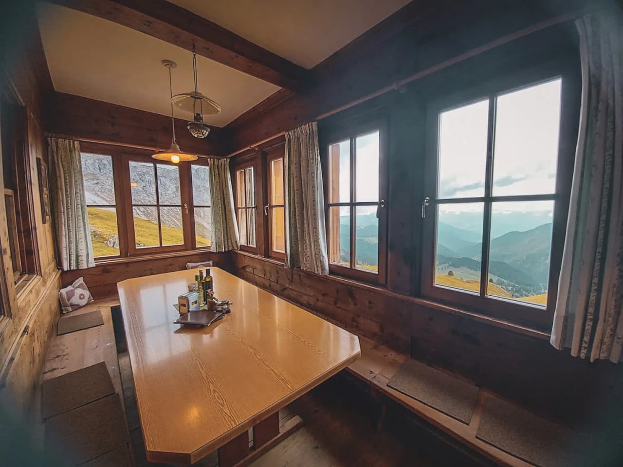 The cosy interior of an Alpine Mountain hut, with views of the majestic Dolomite peaks.
