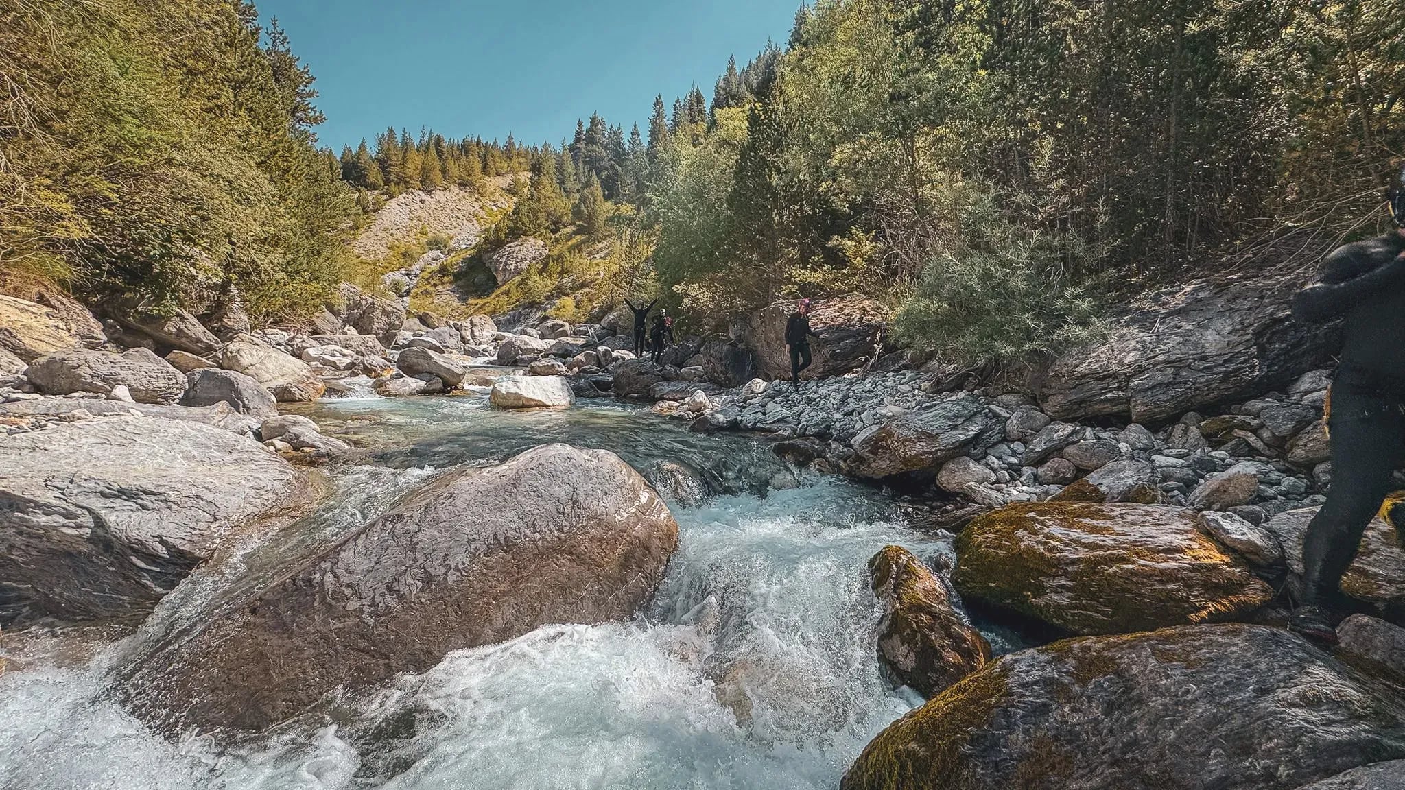 A crystal-clear river surrounded by cliffs, ideal for wilderness adventures.
