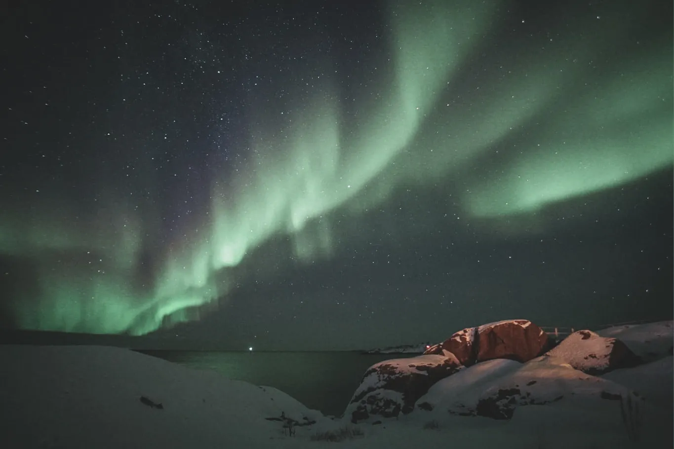 Aurores boréales dans un ciel étoilé sur les fjords glacés de Senja, Norvège. Magique et apaisant.