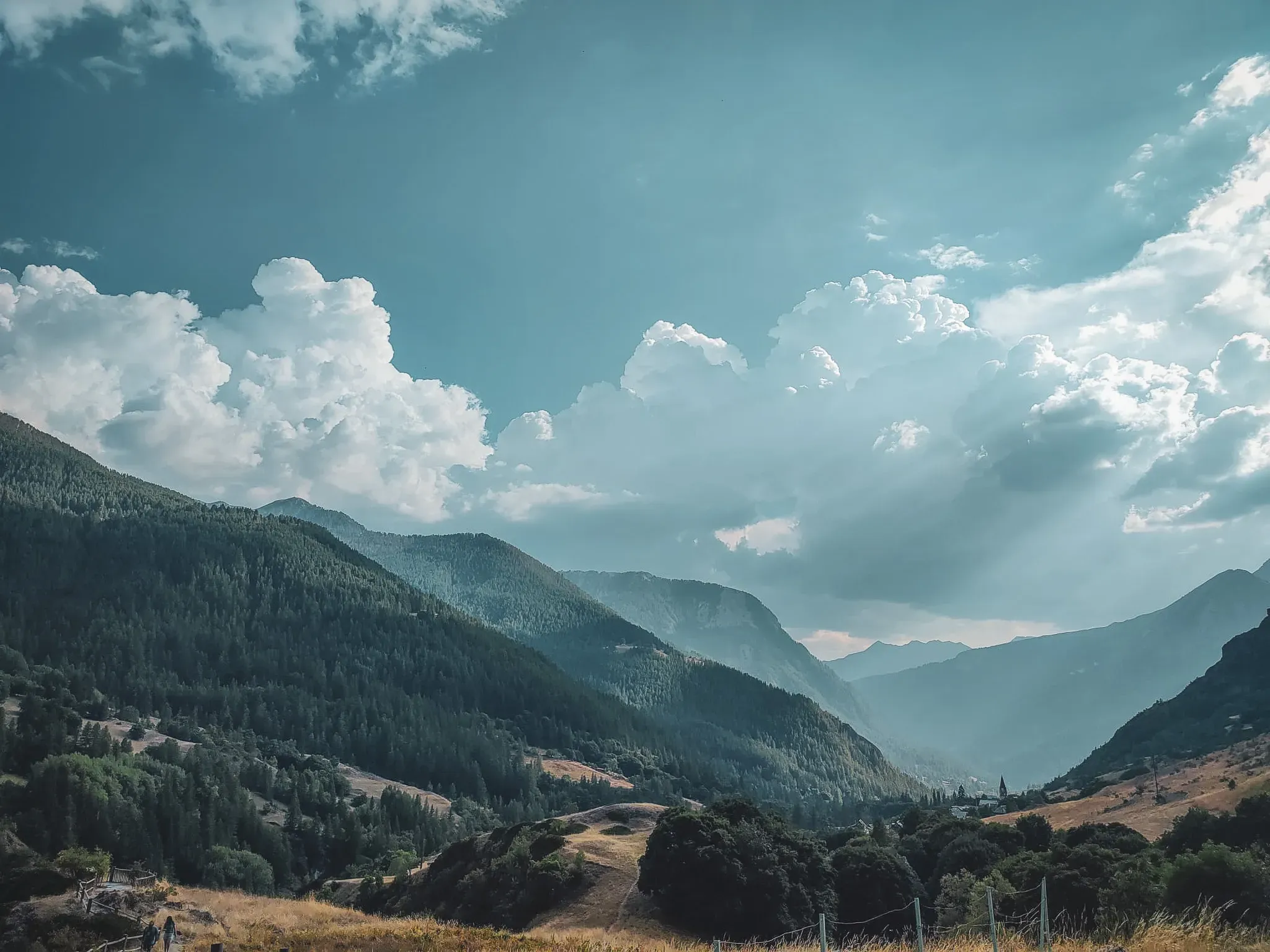 A serene Alpine panorama with majestic mountains and clouds, an invitation to adventure in the great outdoors.