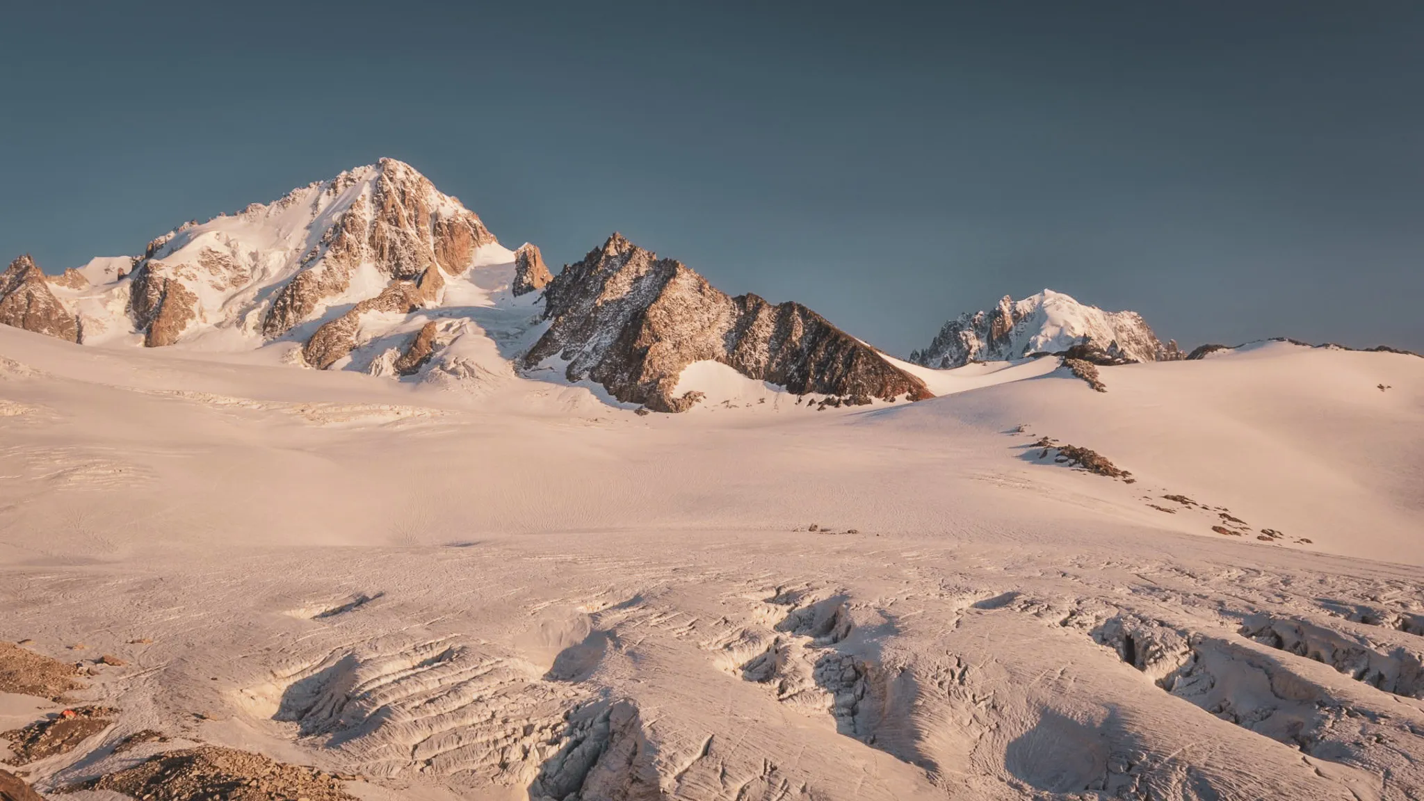 Majestic peaks and sparkling glaciers under clear skies, an invitation to alpine adventure.