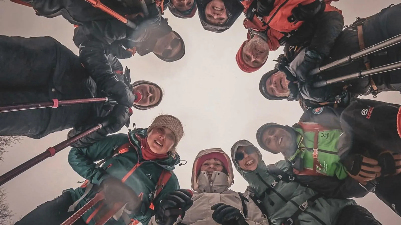 Een vrolijke groep sneeuwschoenwandelt onder de winterse hemel van de Vogezen, klaar voor avontuur.