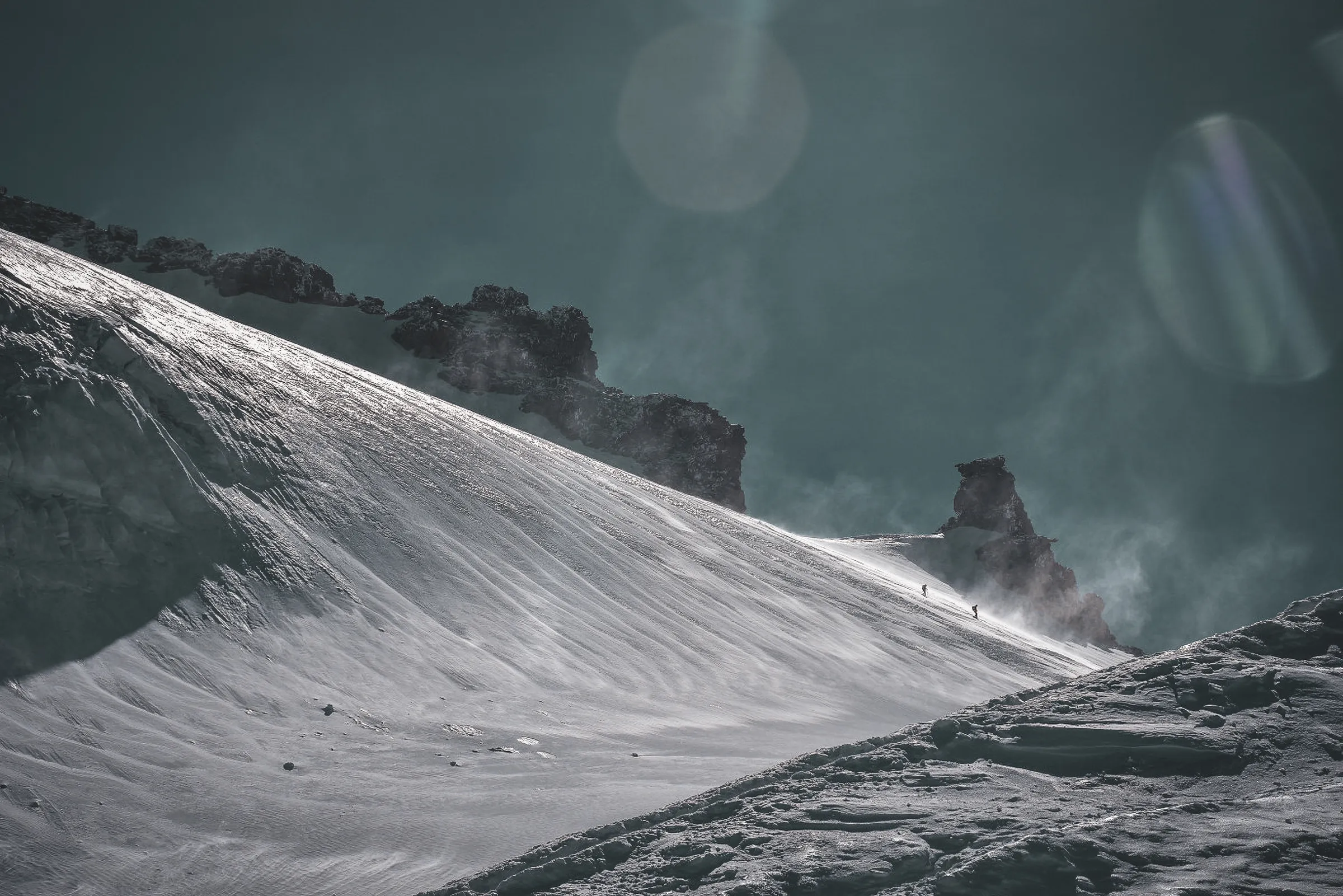 A majestic alpine scene with climbers on a snow-covered slope, ideal for adventure.
