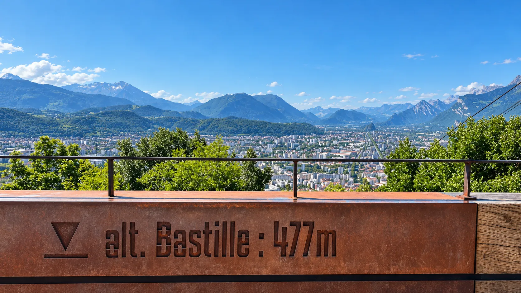 Vue panoramique sur Grenoble depuis la Bastille, avec des montagnes majestueuses en arrière-plan.