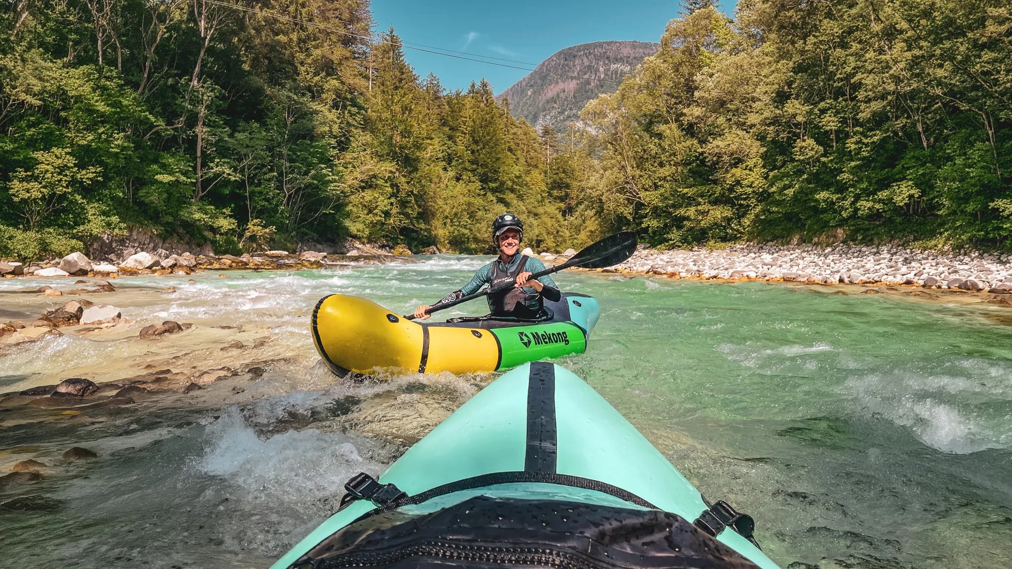 Deux packrafts glissent sur une rivière alpine turquoise, entourée de forêts verdoyantes. Aventure au cœur des paysages slovènes !