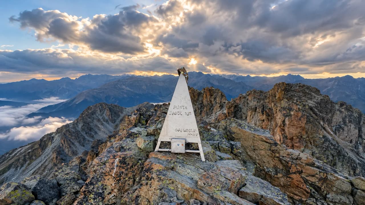Punta Dante at sunset, a majestic peak surrounded by mountains and clouds. An alpine escape!