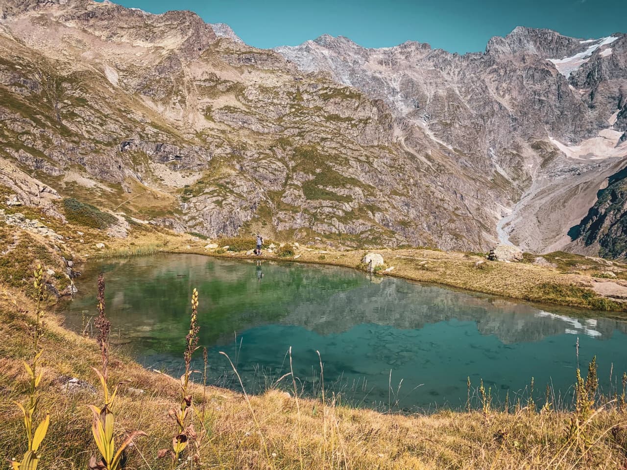 Trek dans les Écrins : lac paisible entouré de montagnes majestueuses, invitation à l'aventure.