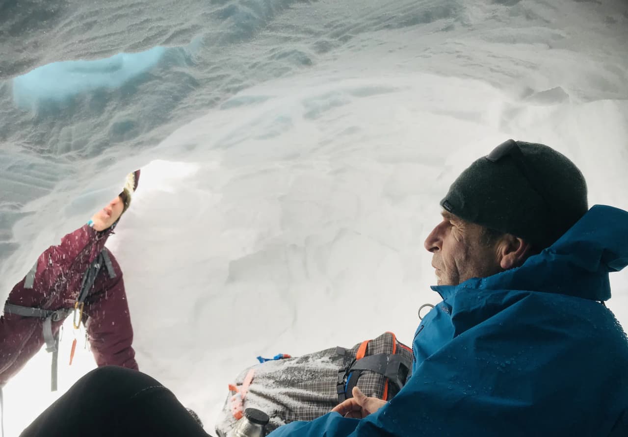 À l'intérieur d'un igloo, deux aventuriers profitent de la magie de l'hiver alpin.
