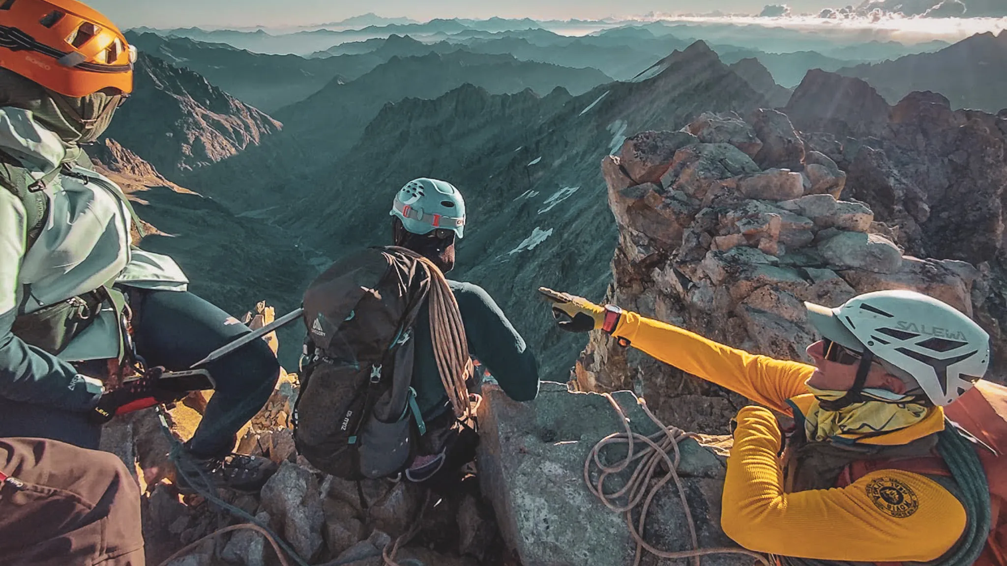 Trois alpinistes sur un sommet, admirant des paysages montagneux à couper le souffle dans les Écrins.