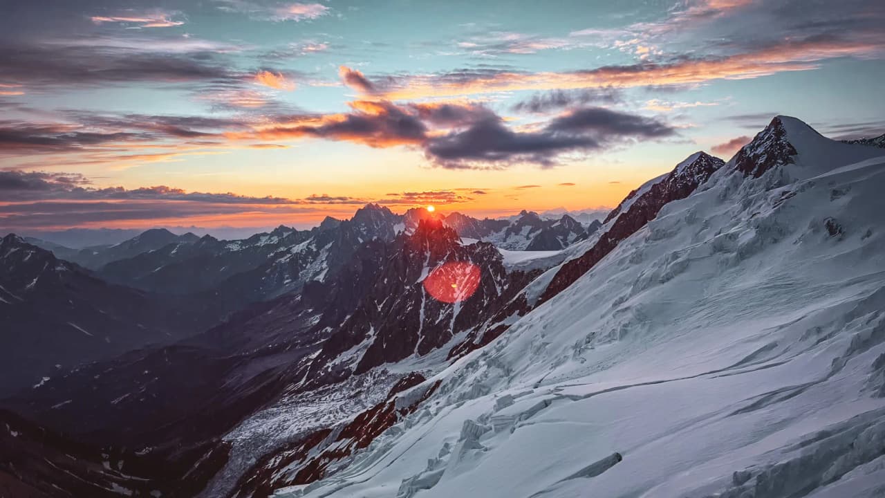 A magnificent sunrise over the snow-capped mountains, an invitation to an alpine adventure.