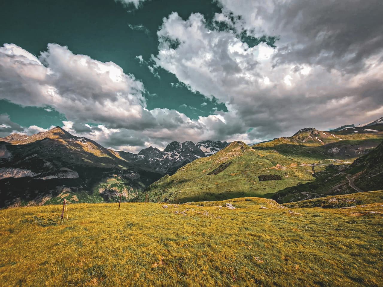 Majestueus Pyreneeënlandschap, weelderig groene valleien en bergen onder een bewolkte hemel.