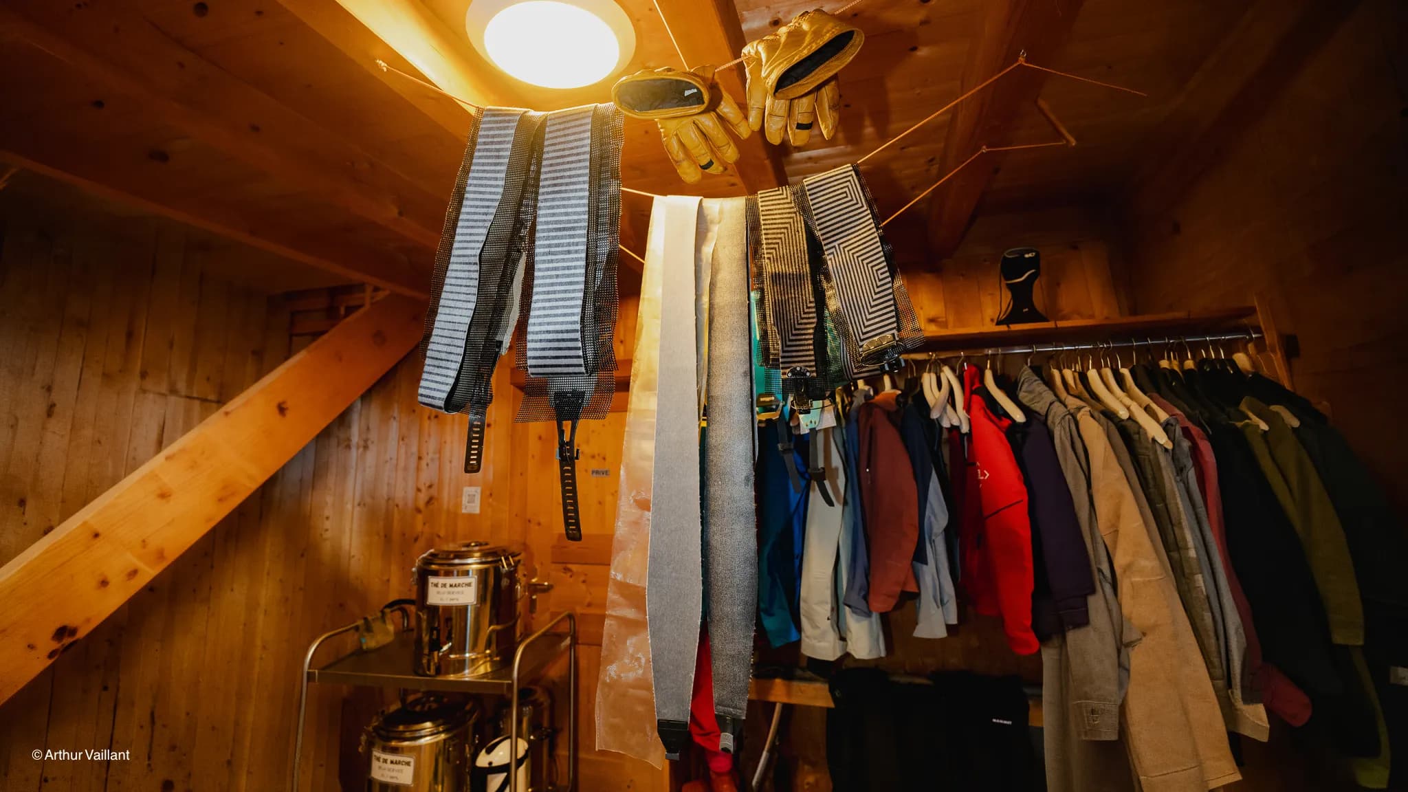 Ski equipment hanging in a wooden mountain hut, ready for an alpine adventure.