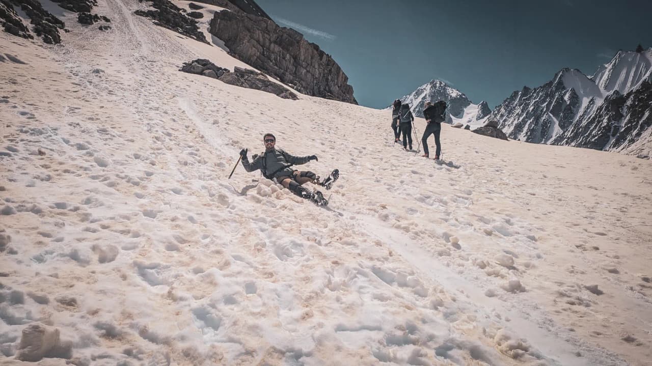 A smiling mountaineer glides across the snow, surrounded by majestic mountains. High-altitude adventure!