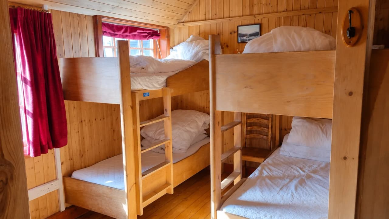 Comfortabele houten kamers met stapelbedden, klaar voor een avontuur in de Hooglanden.