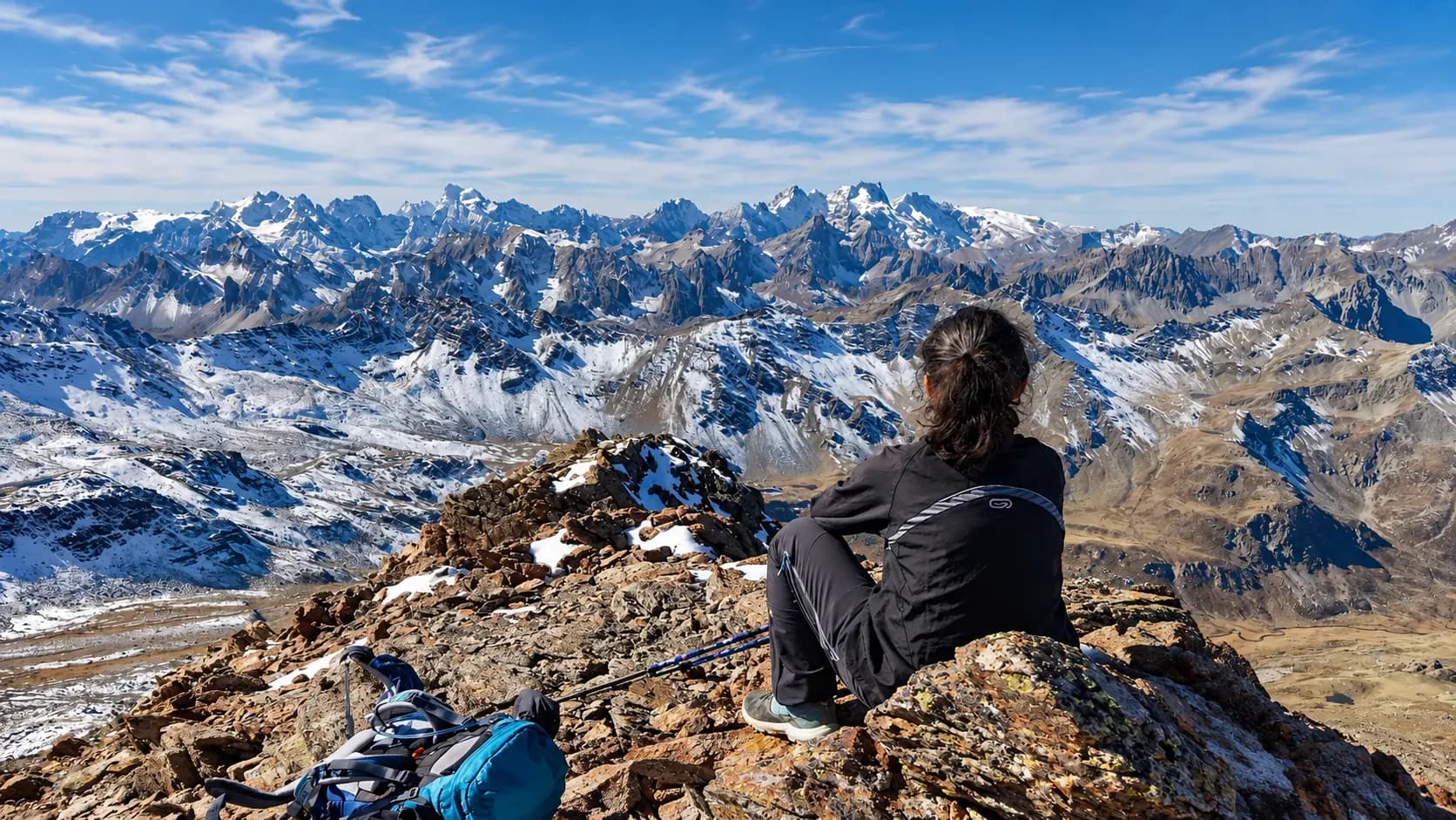 A hiker gazing at a splendid mountain panorama with eternal snows – an invitation to adventure.