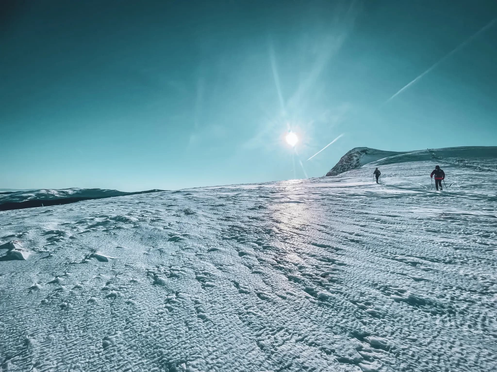 Snow-covered Vosges landscape with hikers under a brilliant blue sky. A winter escape!