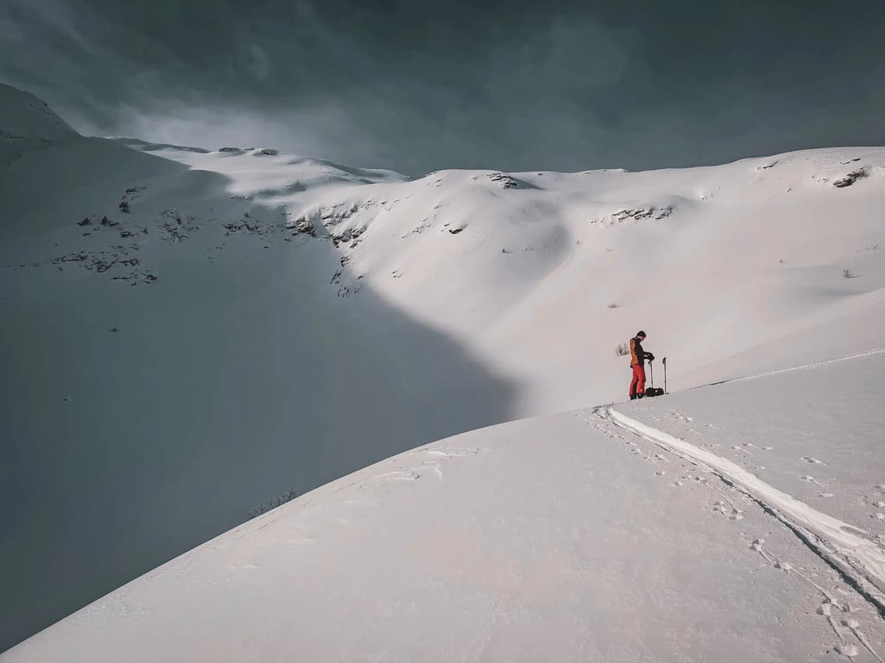 A hiker on a snow-covered ridge, ready to explore the magnificent Écrins.