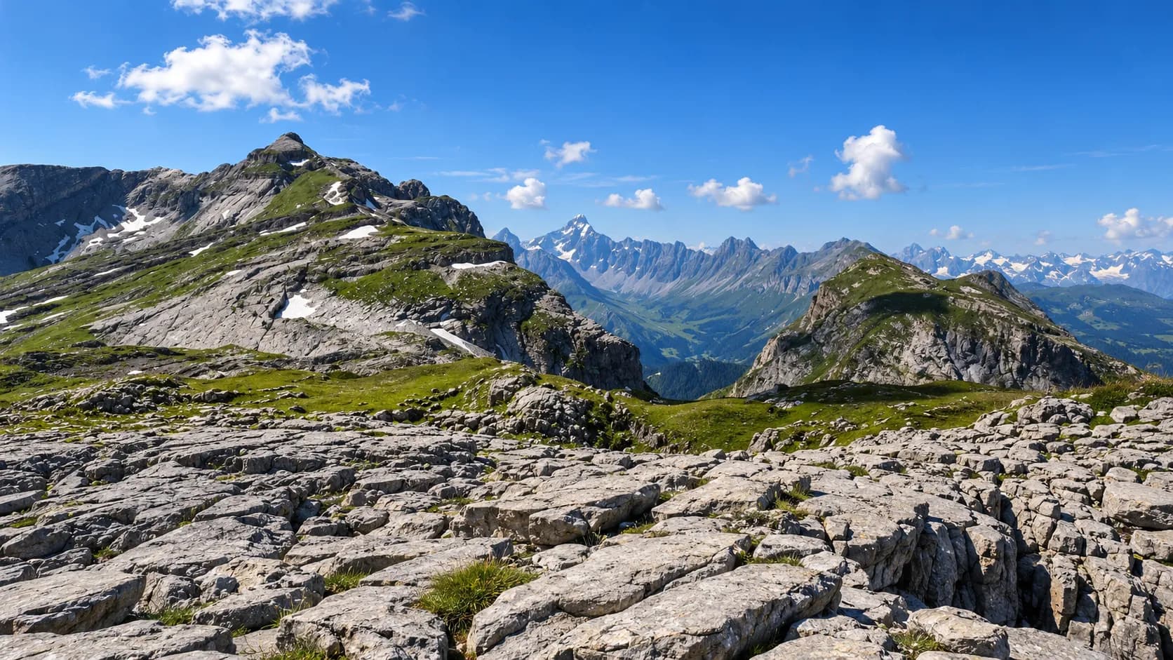 A stunning alpine landscape with mountains, lush green meadows and a blue sky – perfect for an adventure.