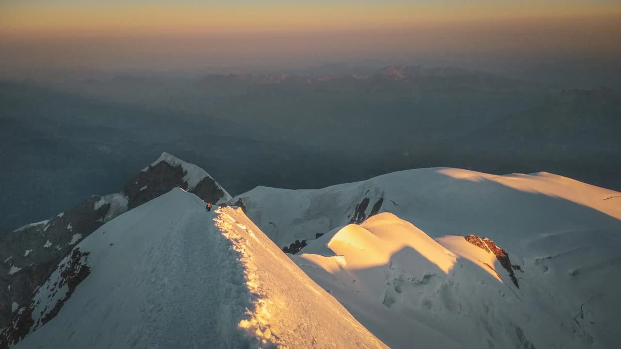 Een adembenemend panoramisch uitzicht vanaf de top van de Mont Blanc, verlicht door de opkomende zon.
