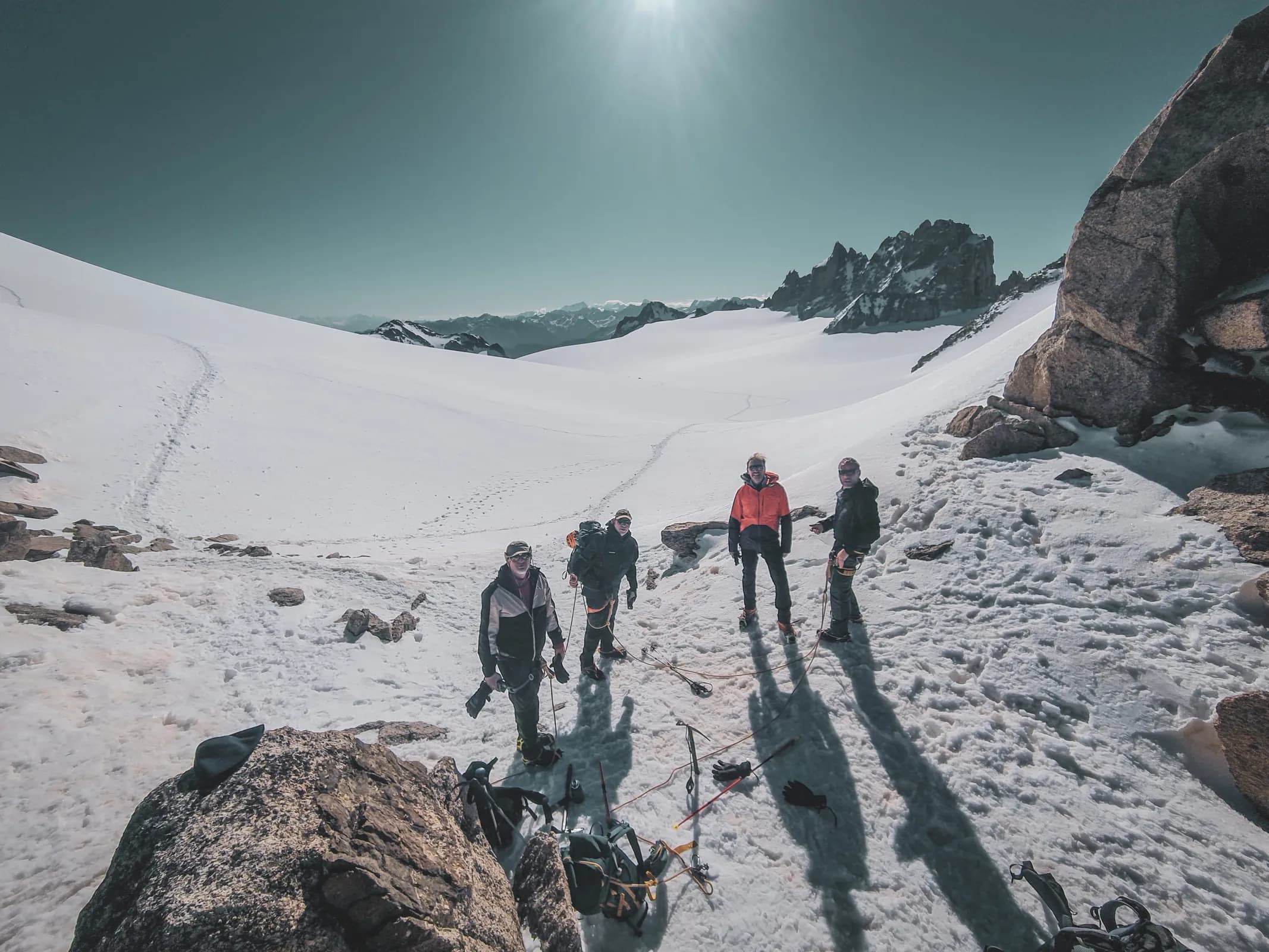 A group of climbers on a glacier, under clear skies, ready for a high mountain adventure.