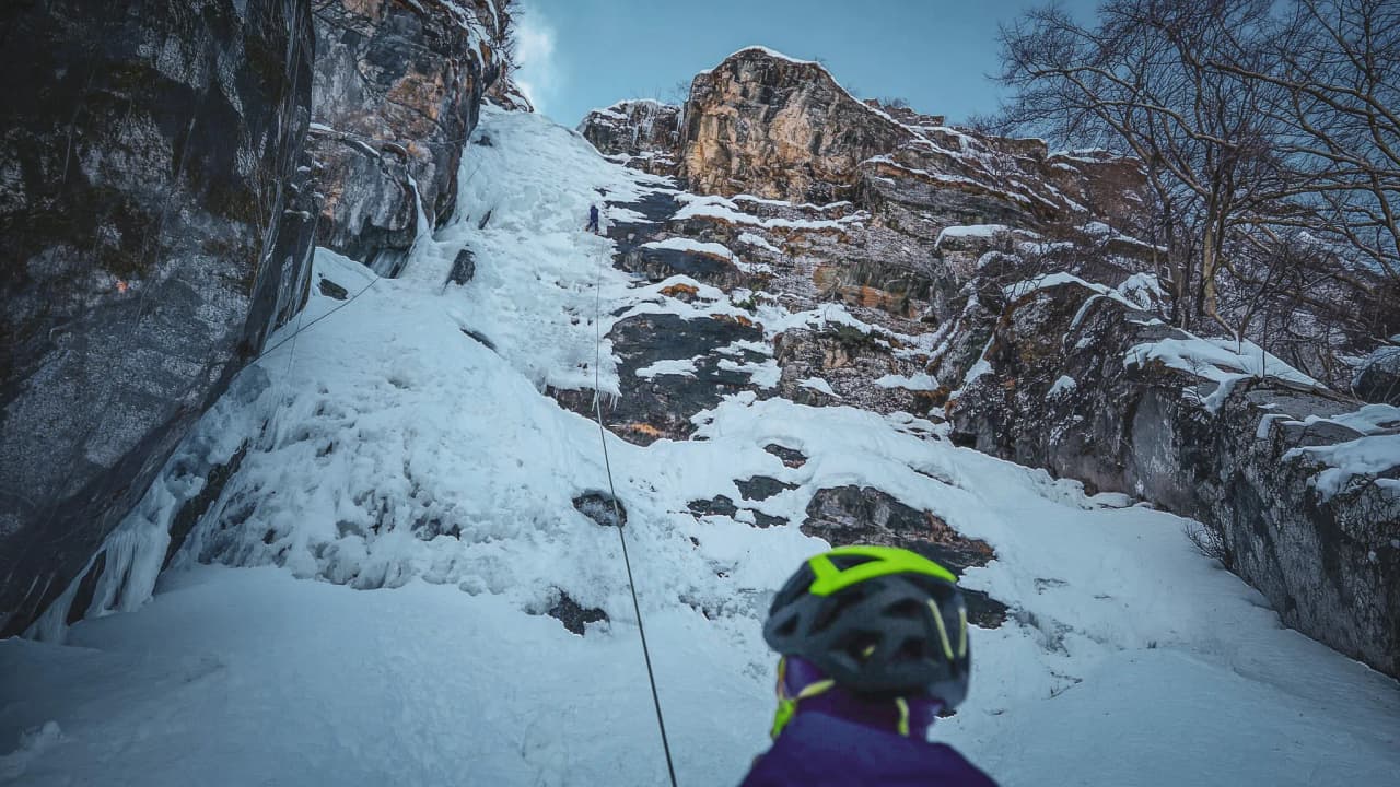 An adventurer facing a majestic icefall in the Italian Alps.