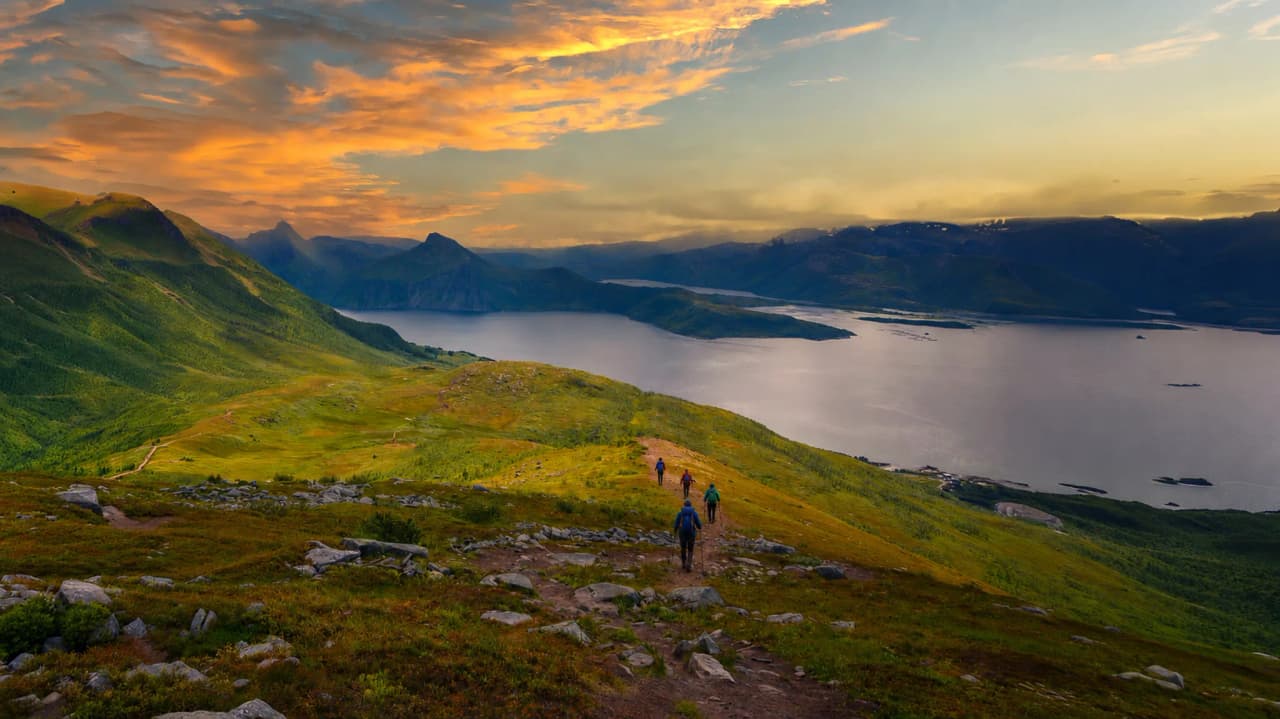 Wandelen op het eiland Senja, met een adembenemend landschap van fjorden en bergen bij zonsondergang.