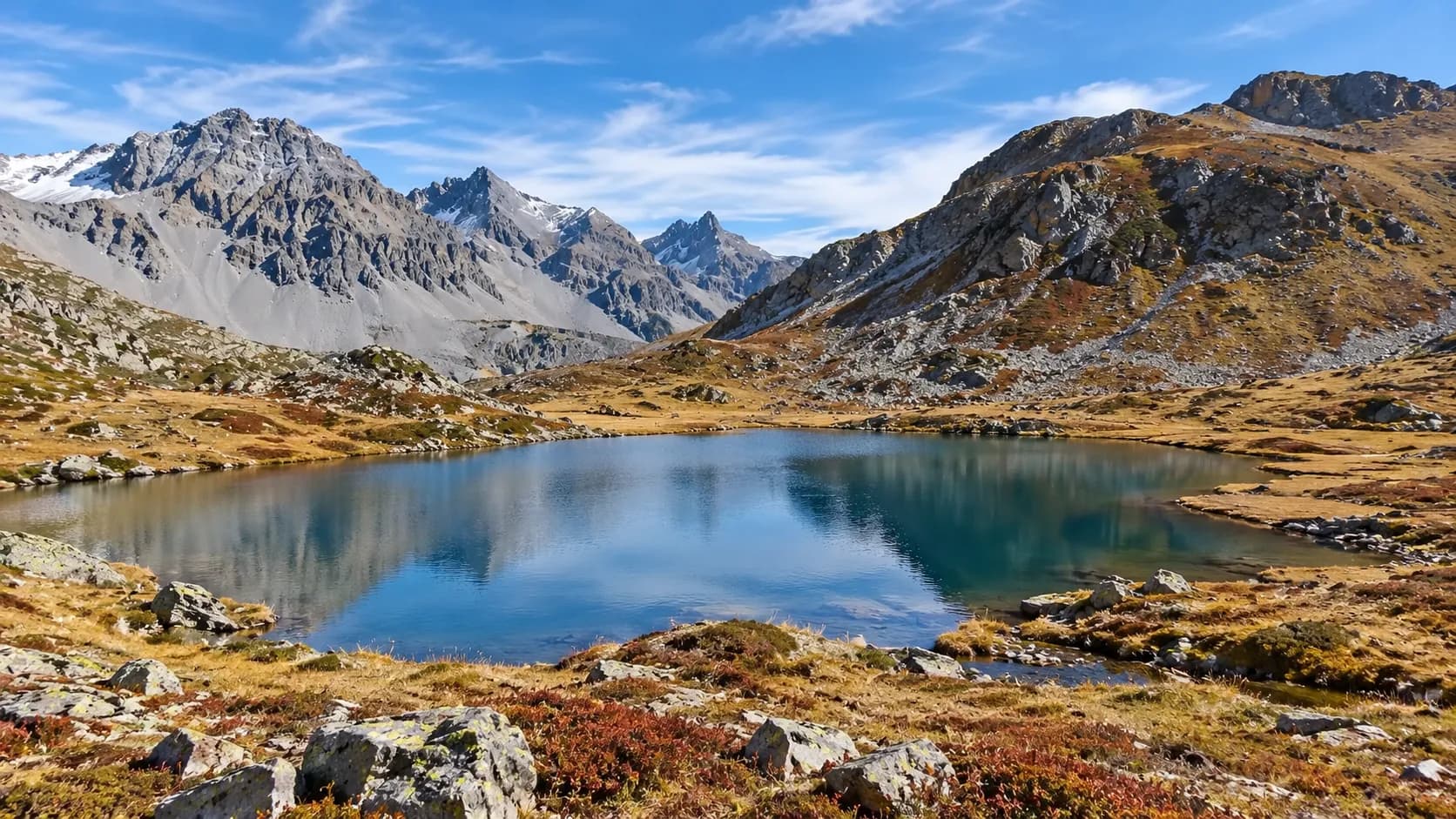A peaceful lake surrounded by majestic mountains and vibrant countryside – an invitation to get away from it all.