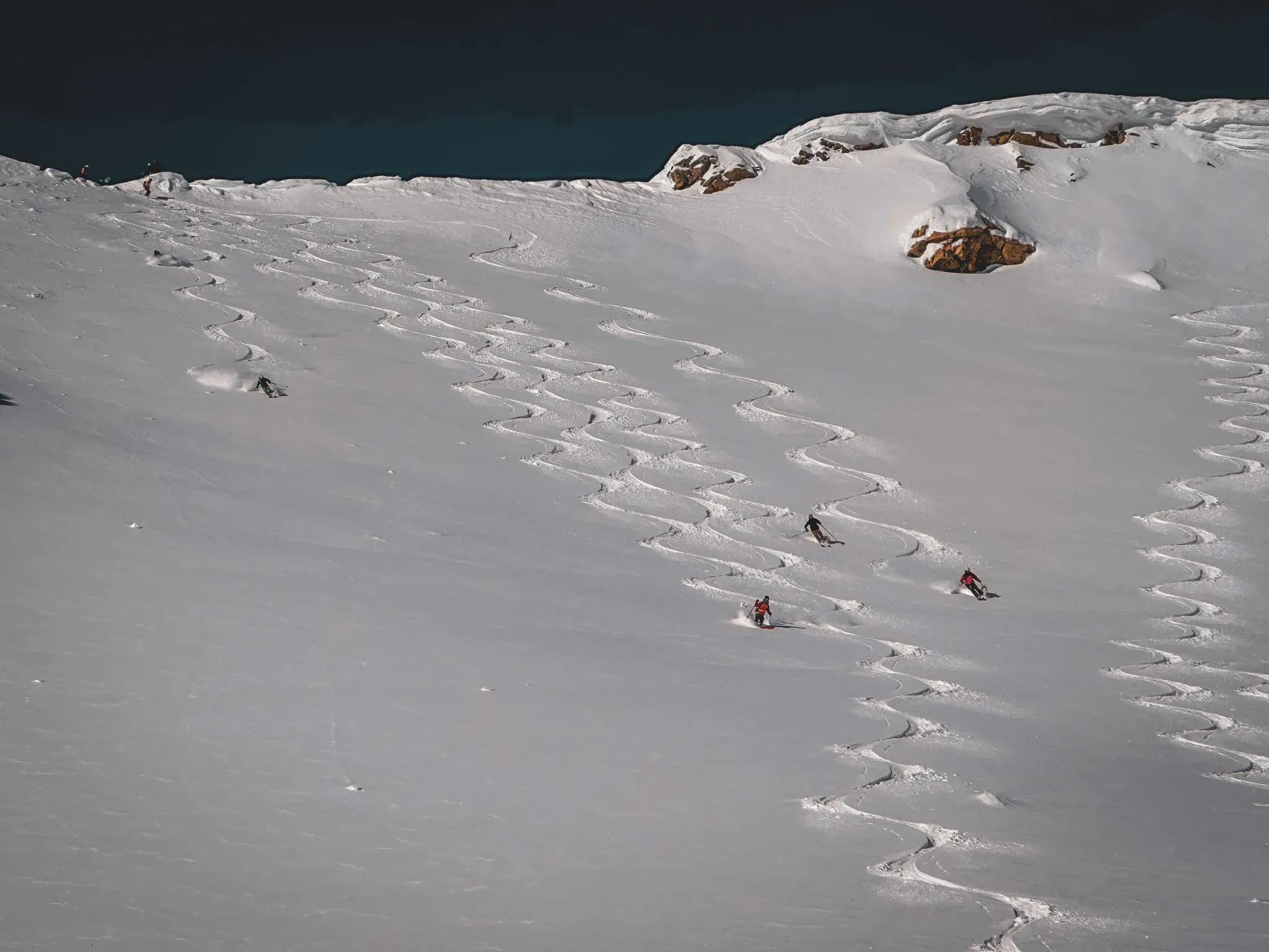 Skiers making furrows in the immaculate snow of the Lyngen Alps, Norway. A unique adventure!
