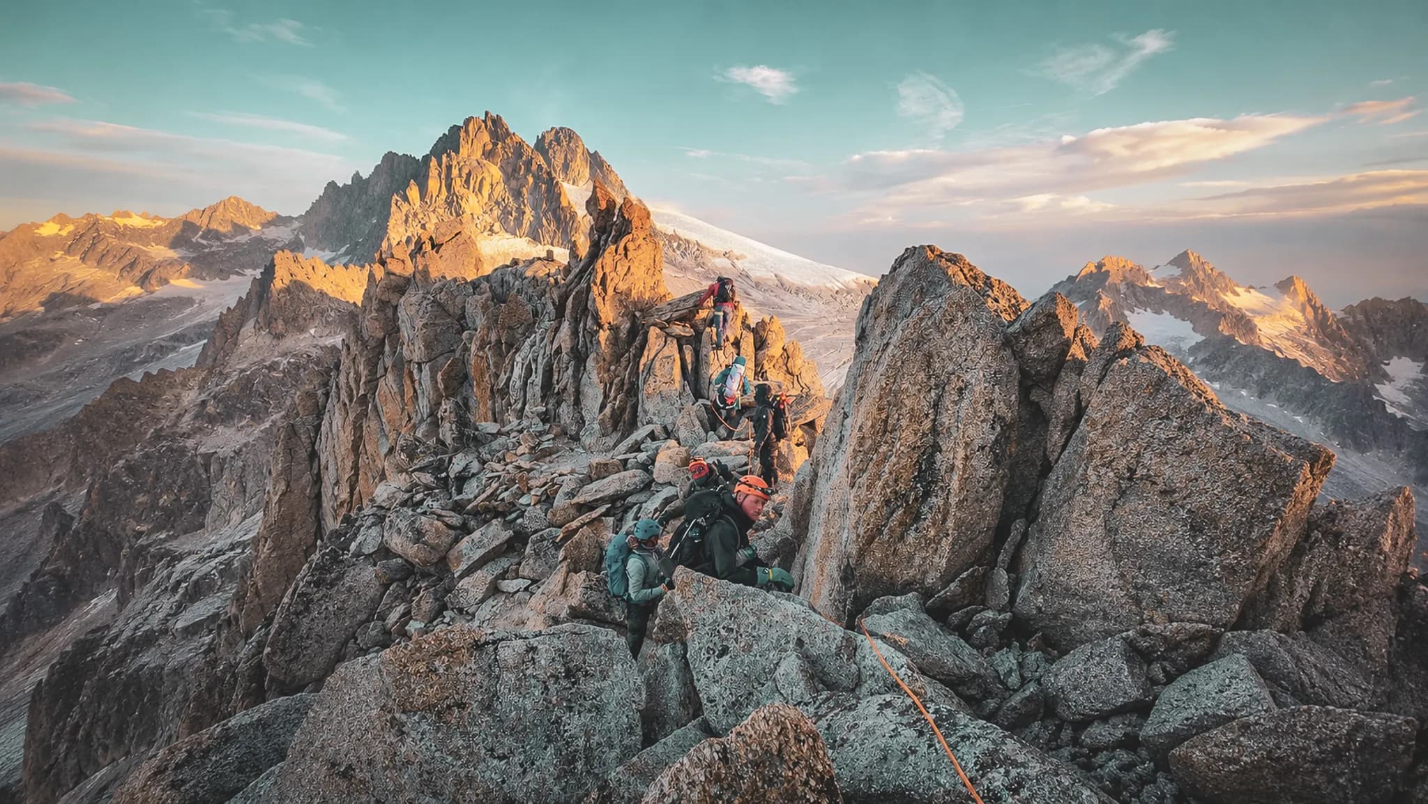 Alpinistes gravissant des rochers au sommet pittoresque, avec des vues spectaculaires sur les montagnes.