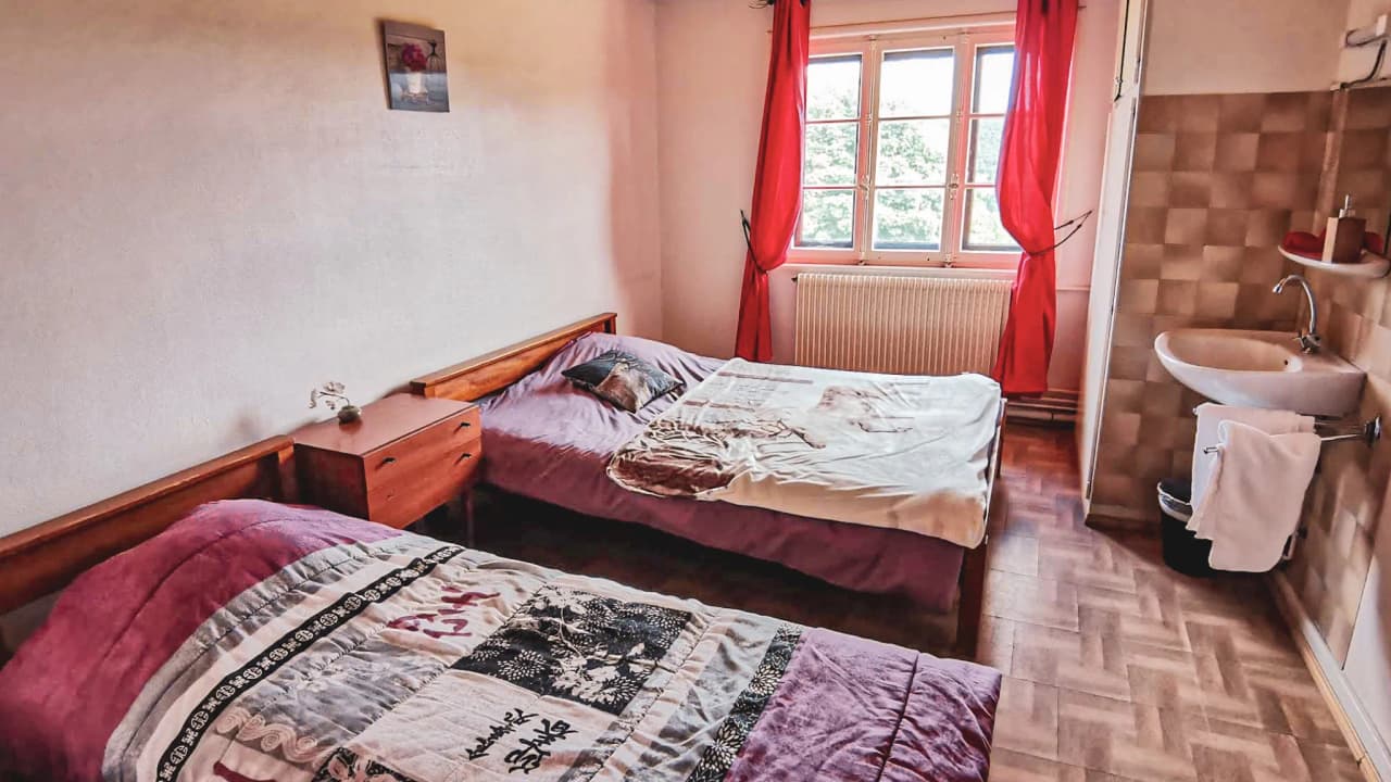Chambre accueillante avec lits confortables, idéale pour se reposer après une randonnée dans les Vosges.