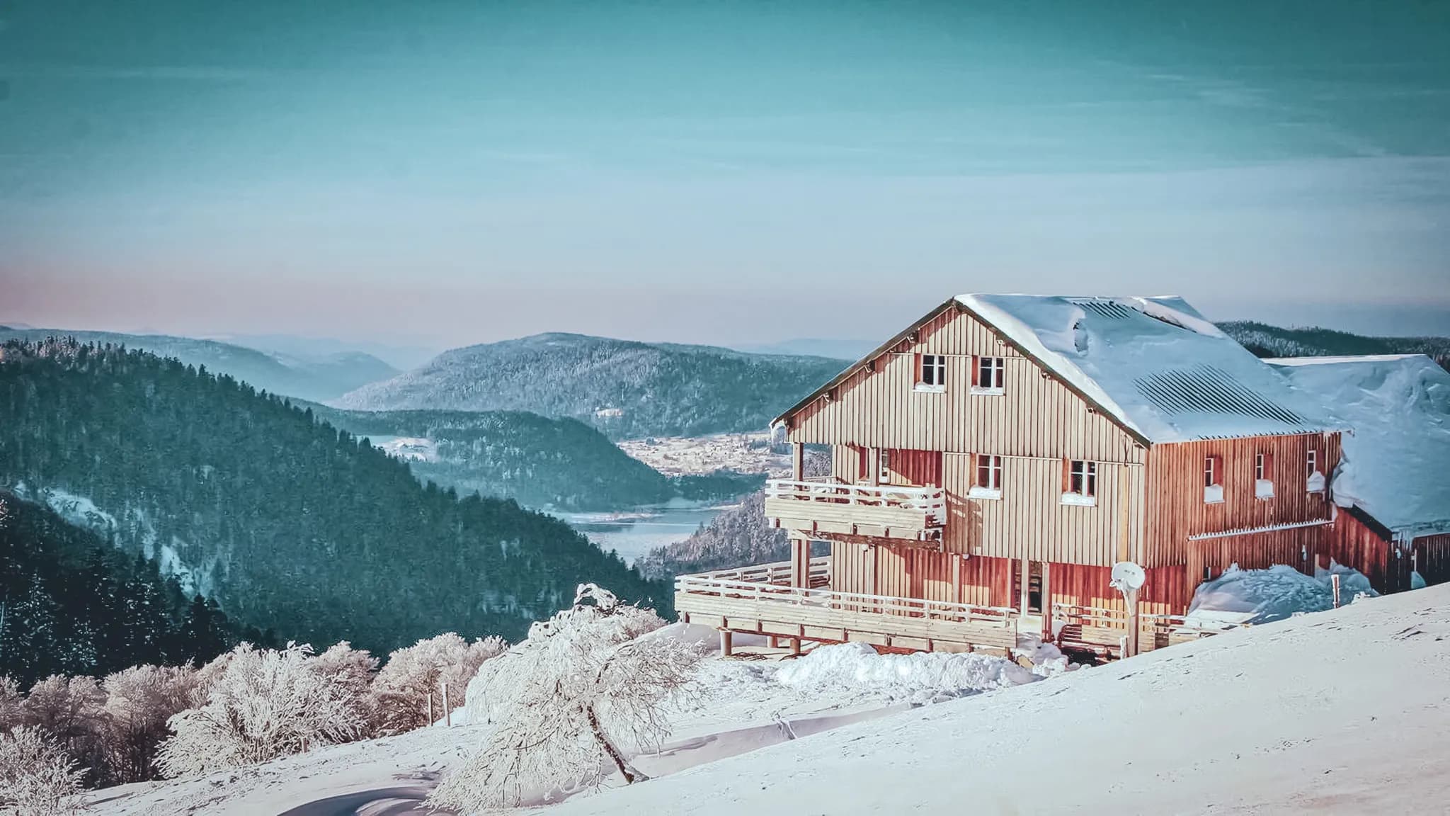 A snow-covered wooden Mountain hut with splendid views of the Vosges mountains.