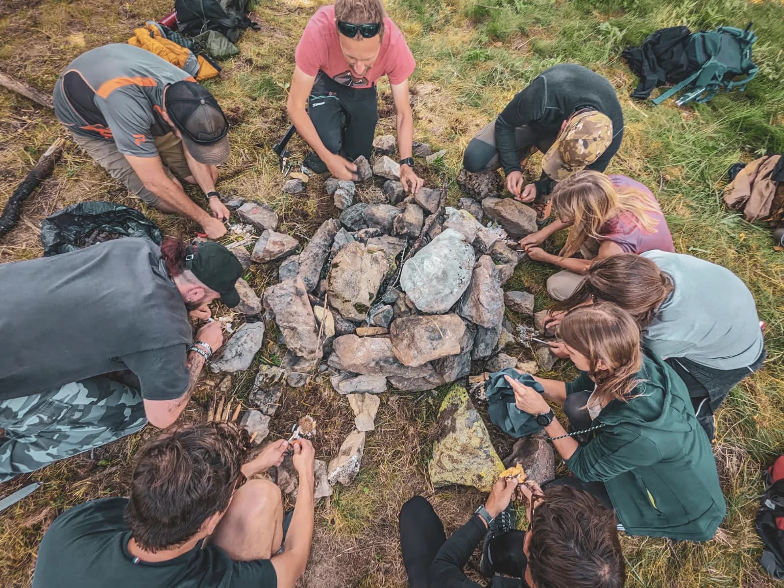 Groupe en pleine nature, apprenant à allumer un feu au milieu des Alpes. Aventure garantie !