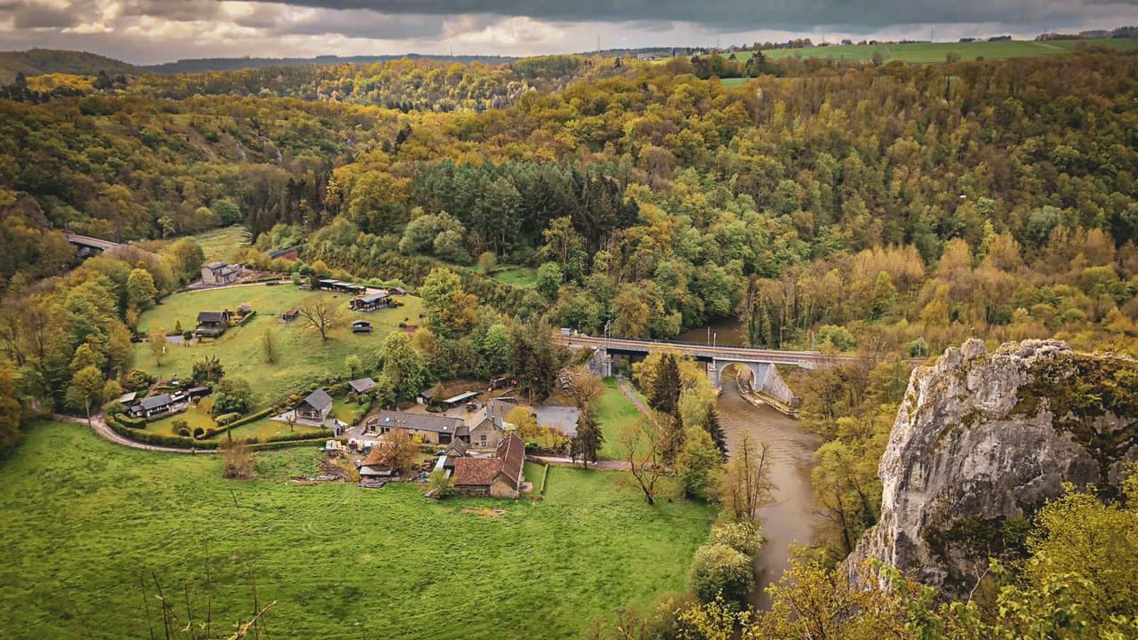 Panoramic views over the lush green valley of the Lesse, a natural setting perfect for adventure.