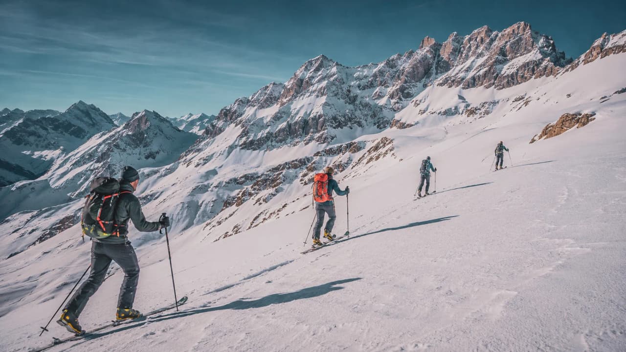 A group of skiers on a ski tour through a magnificent, snow-covered alpine landscape.
