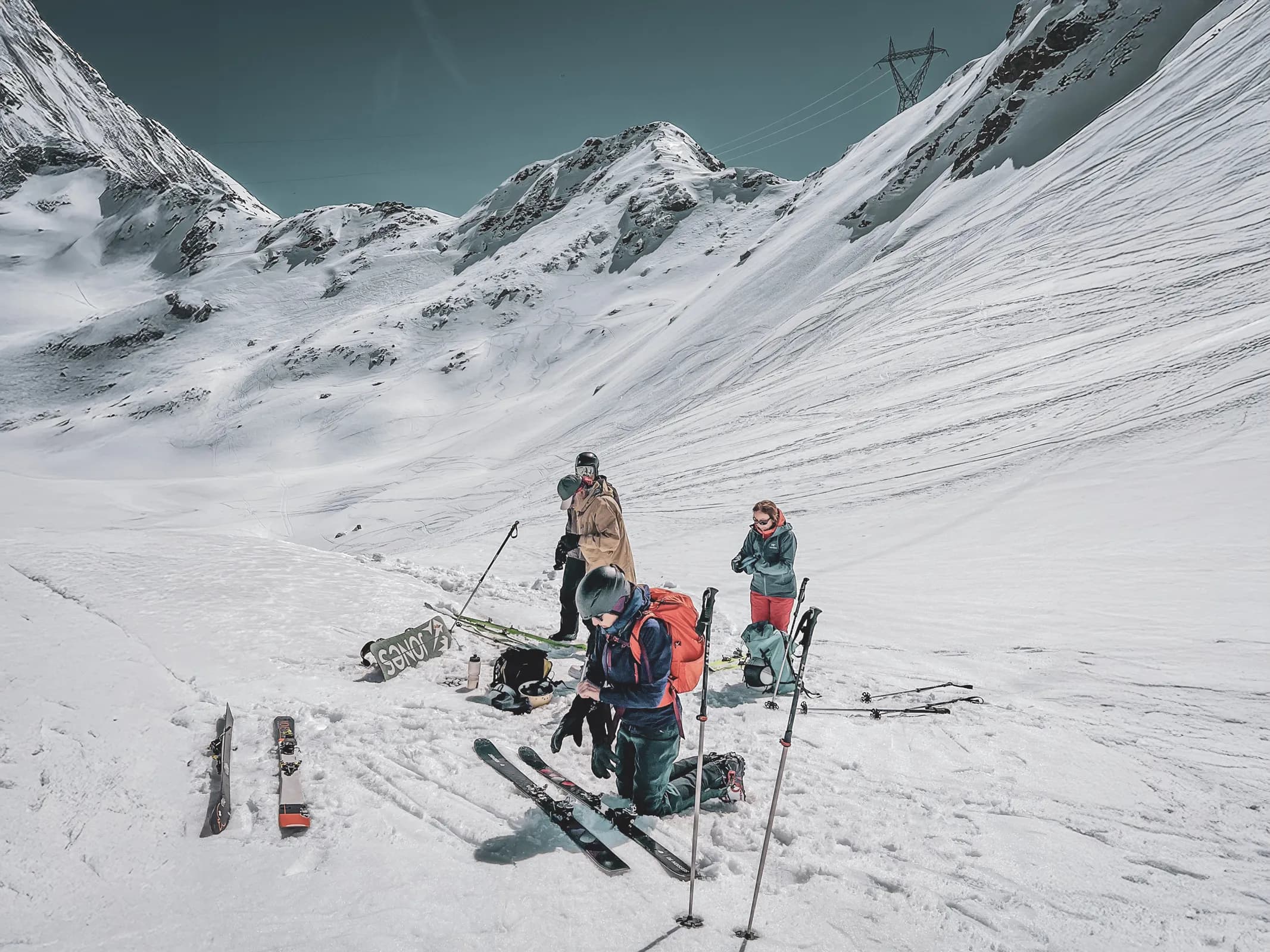 Groupe de skieurs se préparant à l'aventure dans un paysage alpin enneigé spectaculaire.