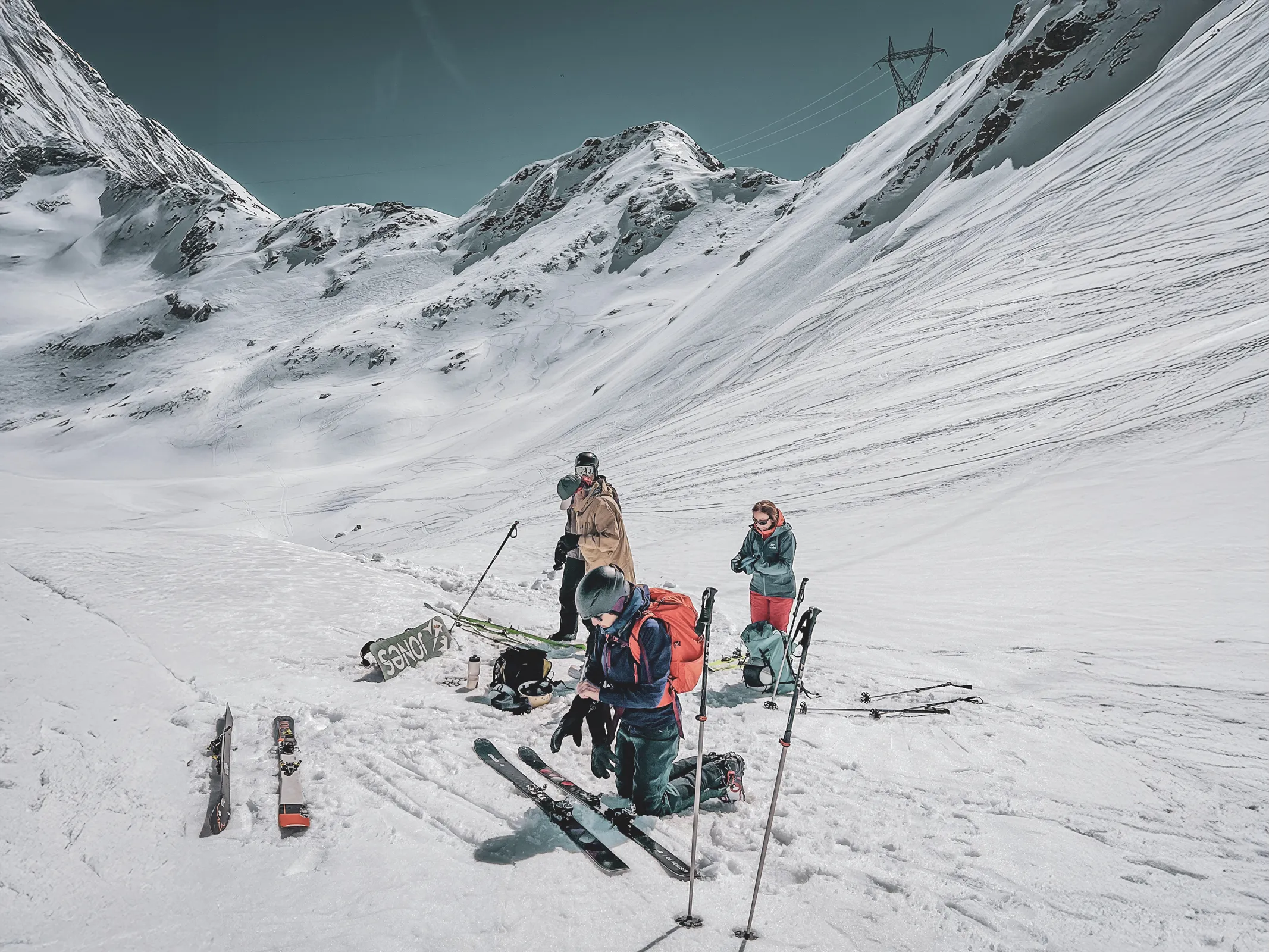 Groupe de skieurs se préparant à l'aventure dans un paysage alpin enneigé spectaculaire.