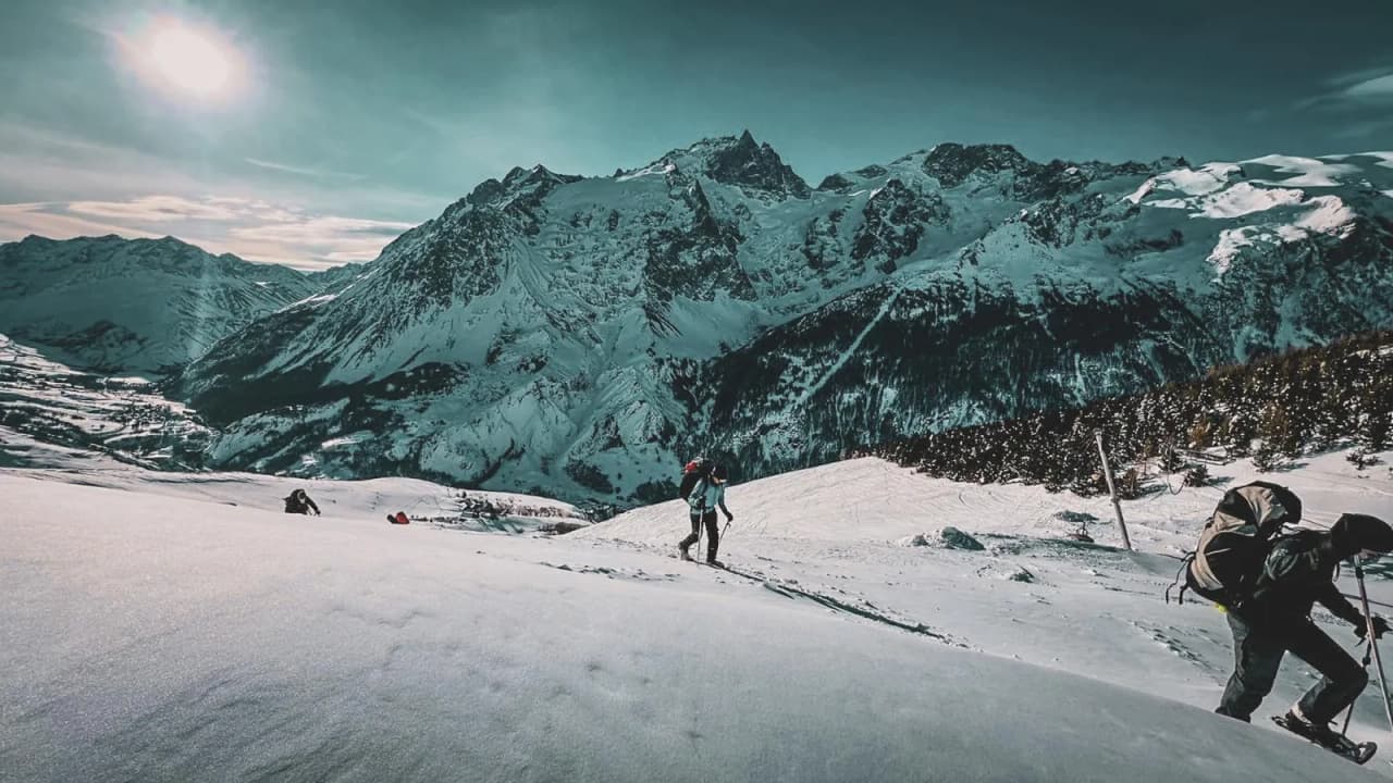 "Sneeuwschoenwandelaars in een besneeuwd landschap, met uitzicht op het majestueuze Cerces-gebergte".