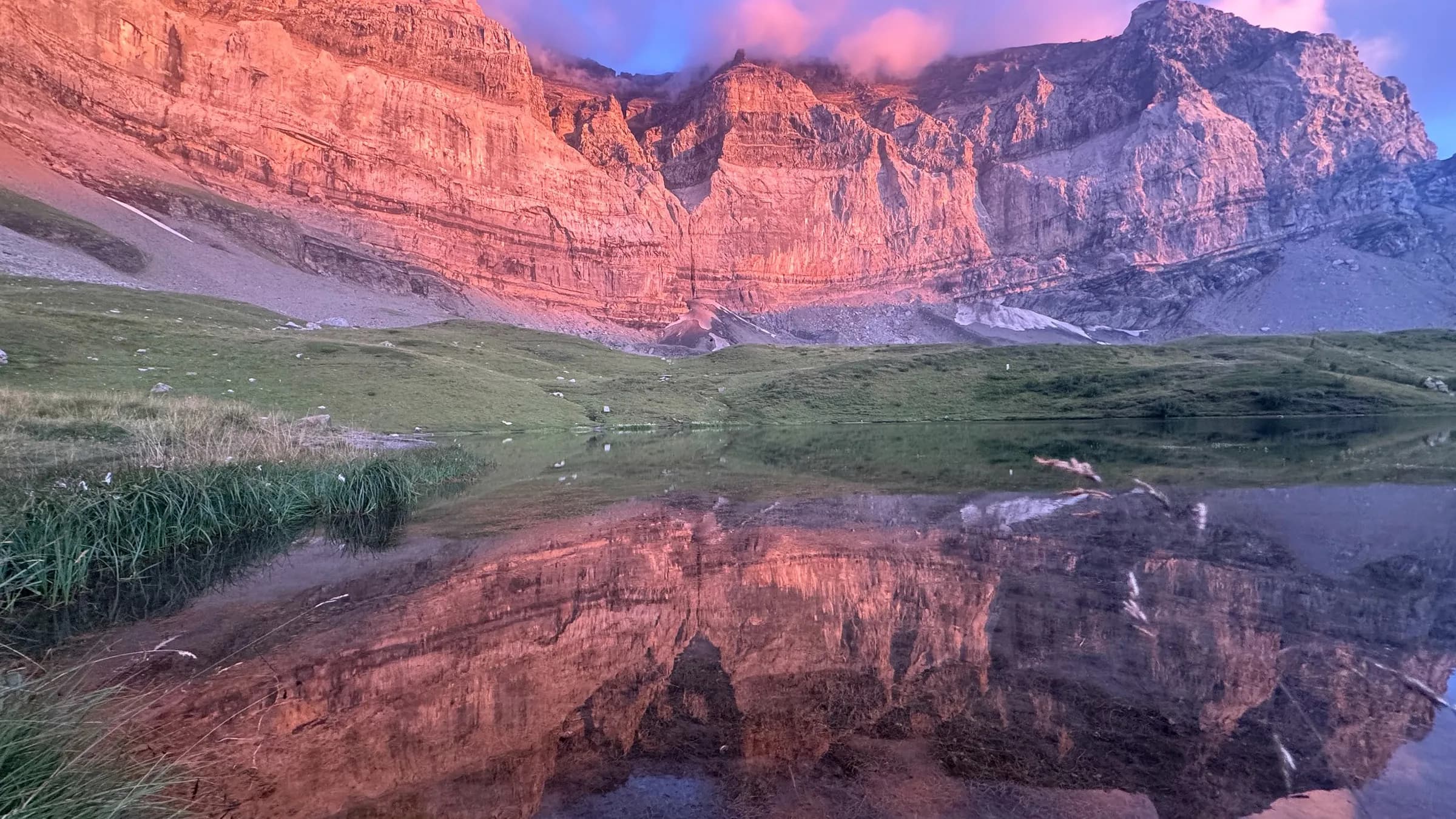 Reflet des majestueuses Dents du Midi au crépuscule sur un lac alpin paisible.