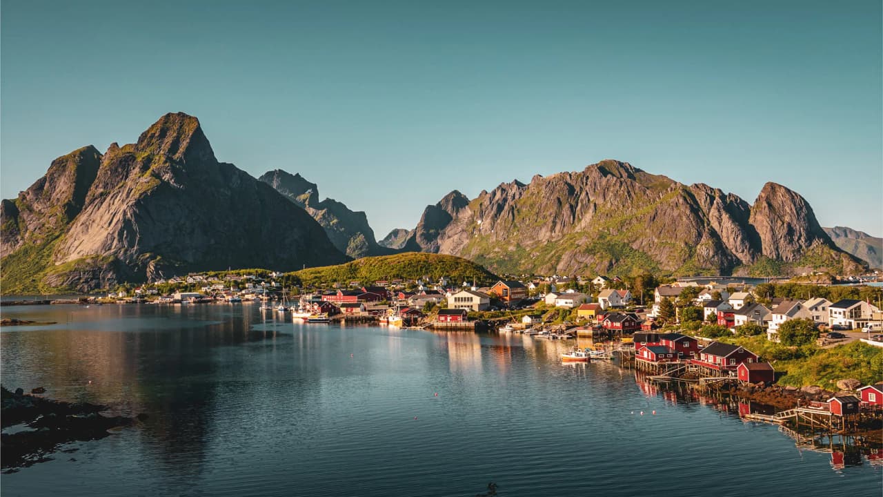 The enchanting landscape of the Lofoten Islands: majestic mountains and colourful houses on the water's edge.