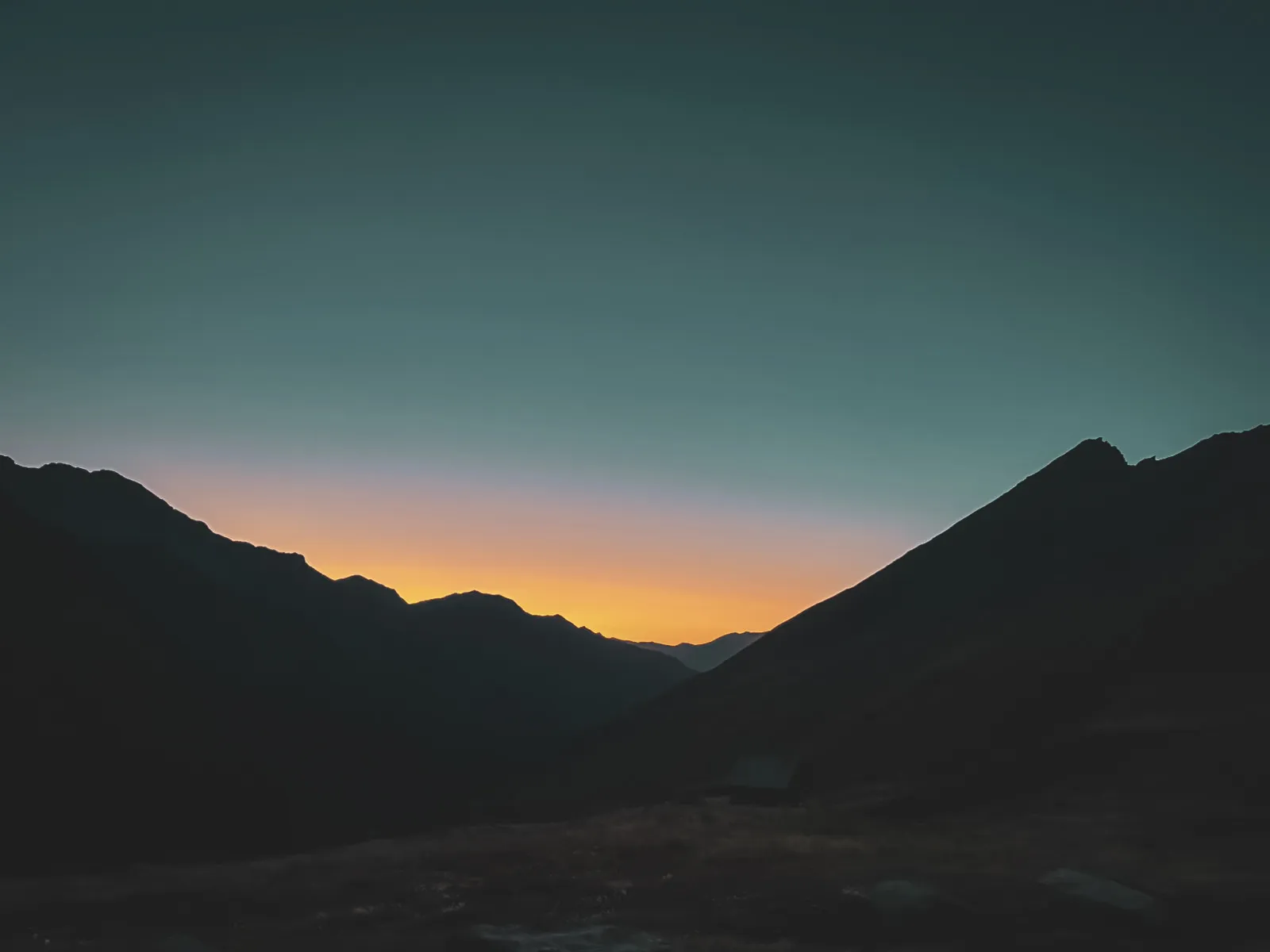 Het majestueuze silhouet van de bergen in de schemering, een belofte van alpine avonturen.