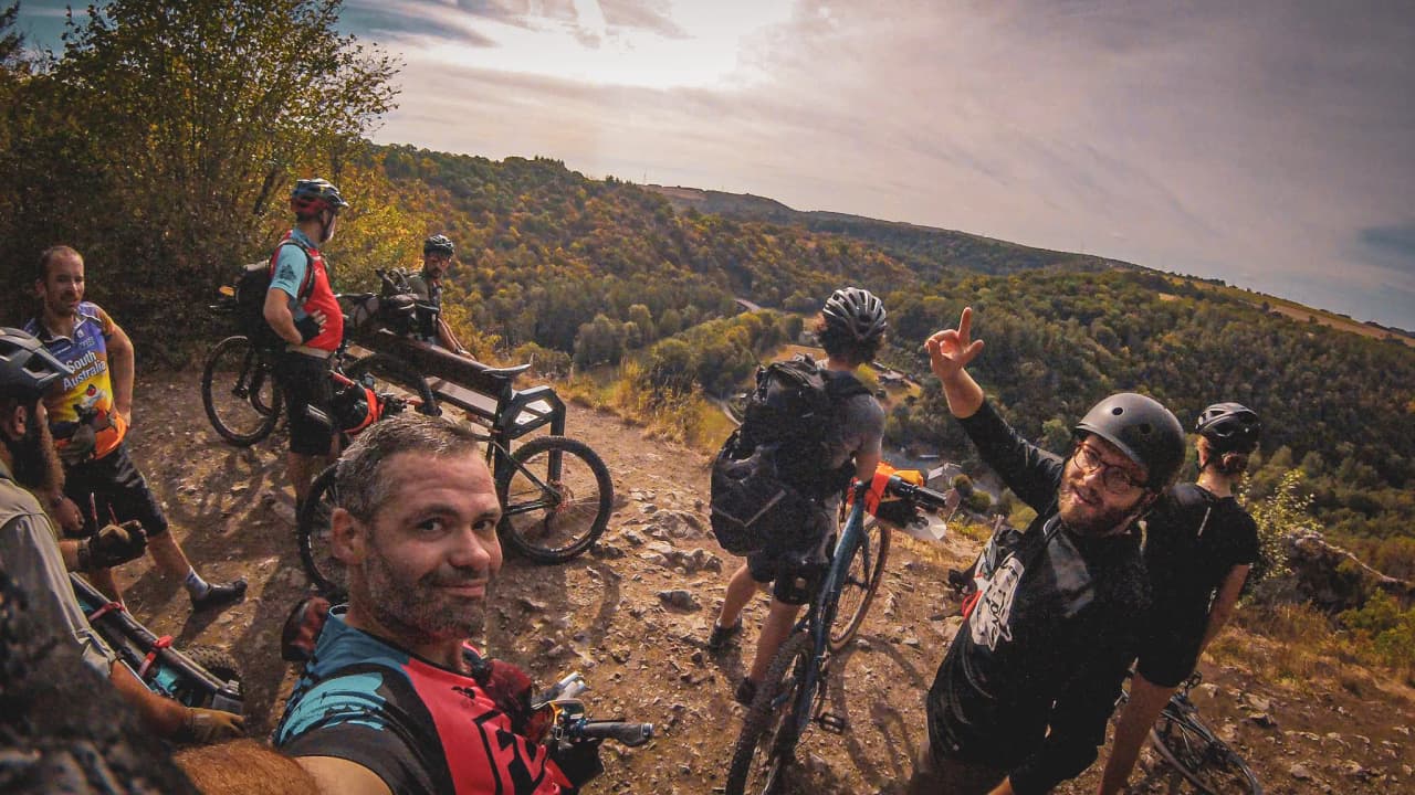 A group of adventurers on mountain bikes admiring the wild landscape along the banks of the Lesse valley.